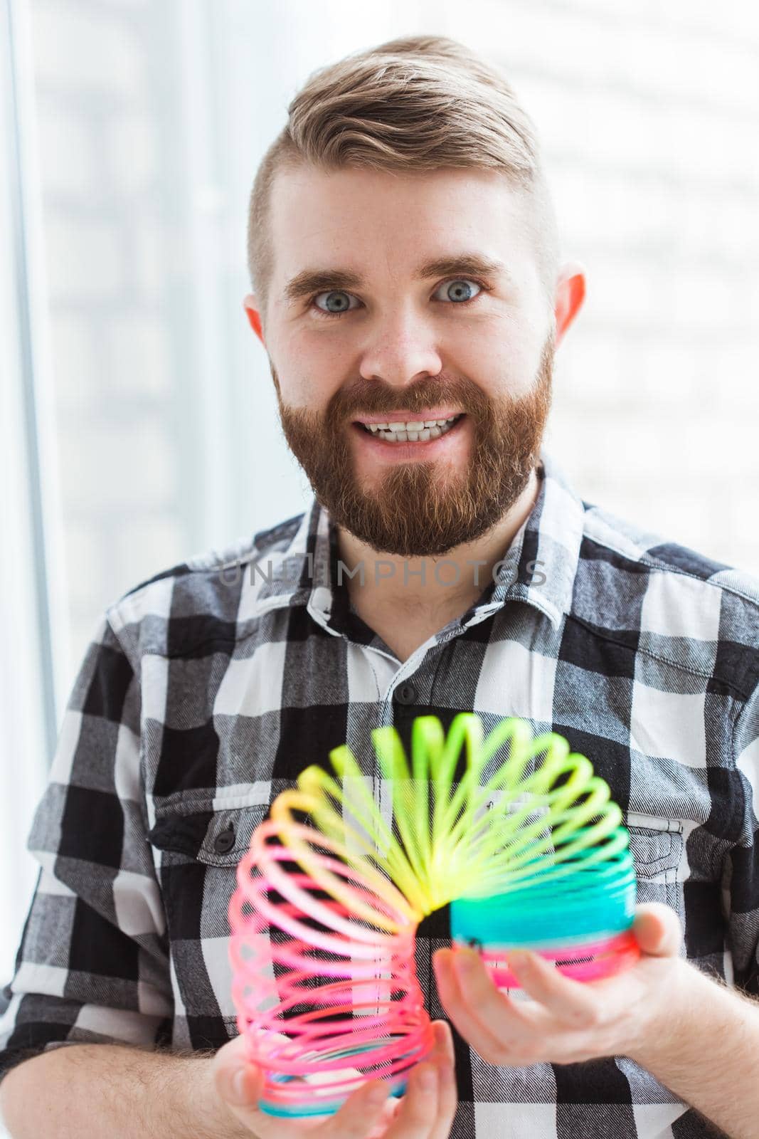 UFA, RUSSIA - April 3, 2019 : man playing with a slinky indoors.