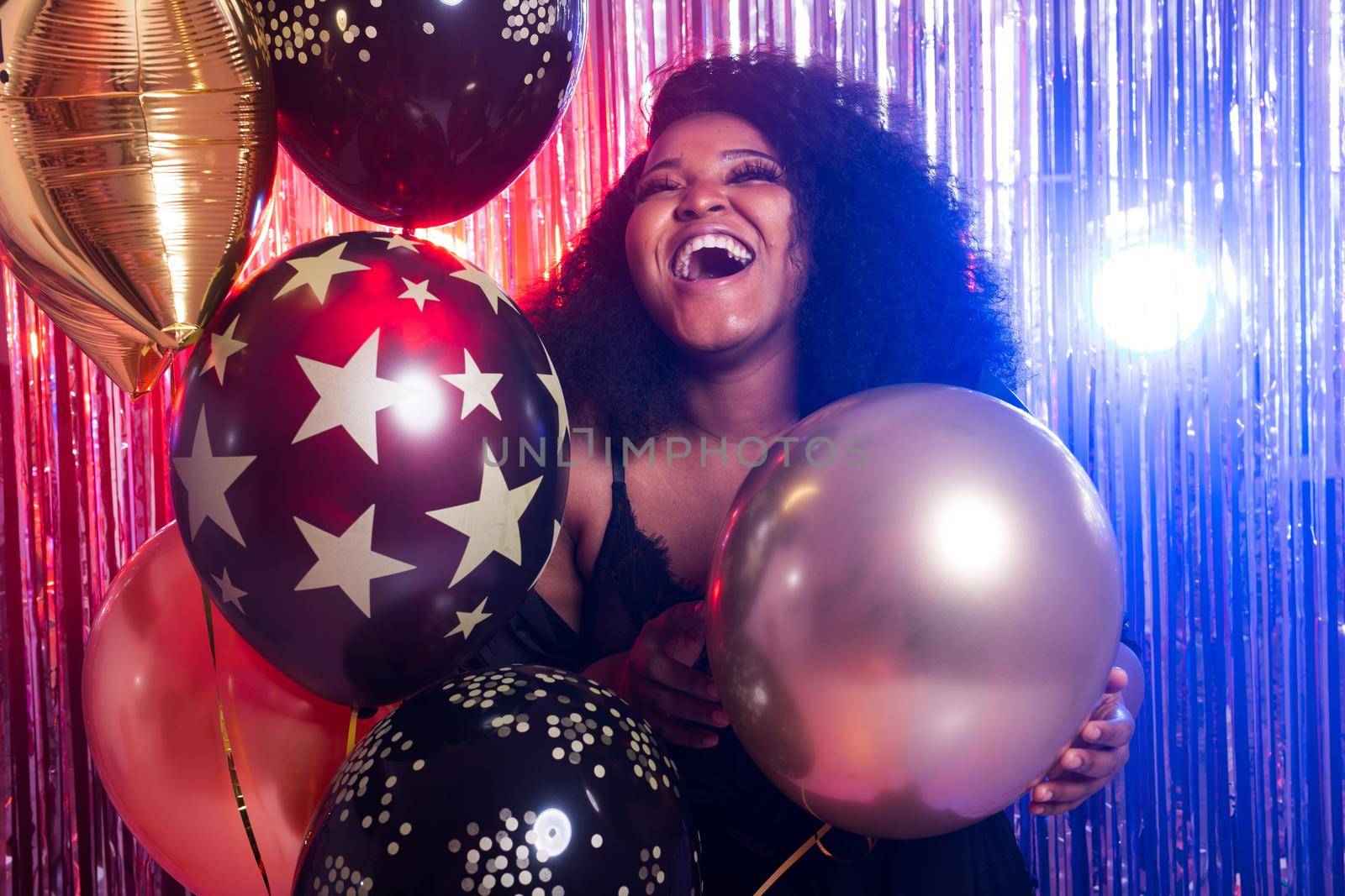 Portrait of a beautiful african american woman against twinkling background. Birthday party, nightclub and nightlife concept. by Satura86