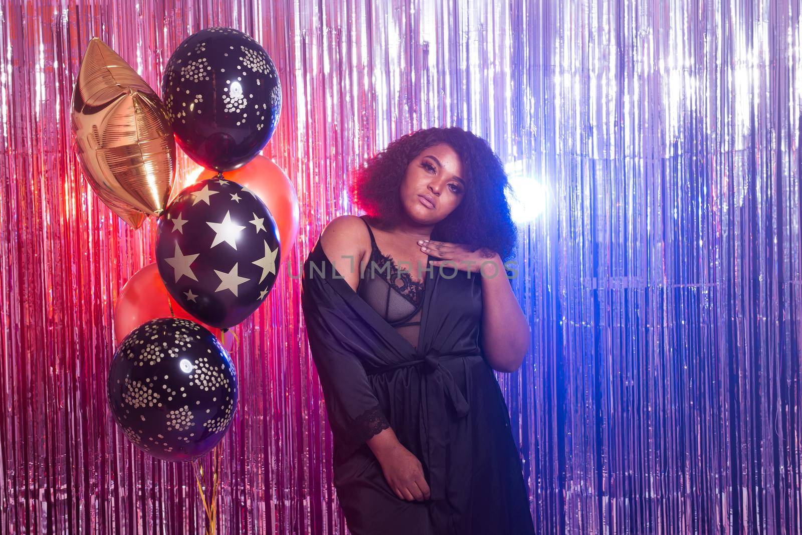 Portrait of a beautiful african american woman against twinkling background. Birthday party, nightclub and nightlife.