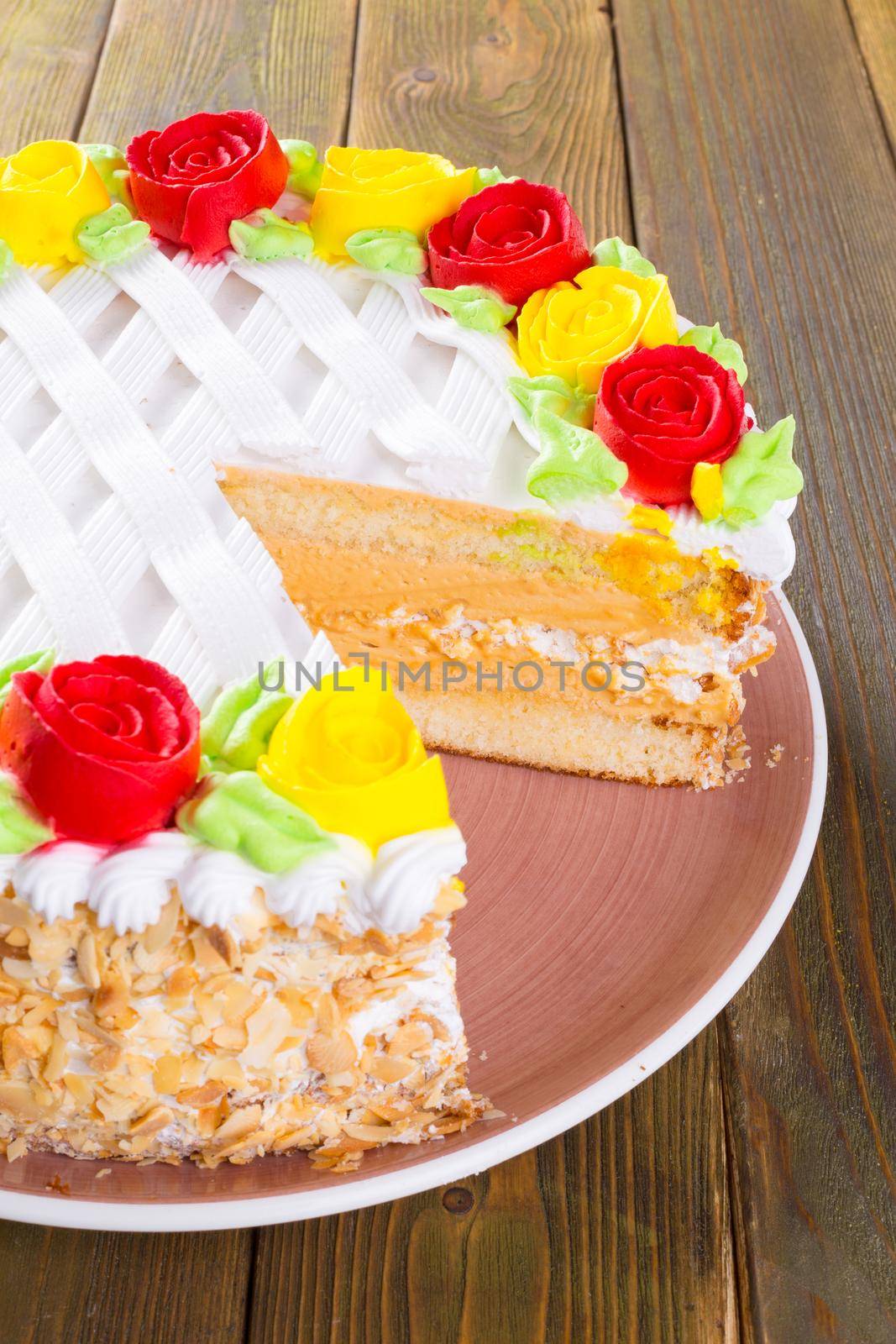 Cut biscuit cake on plate on wooden table close up