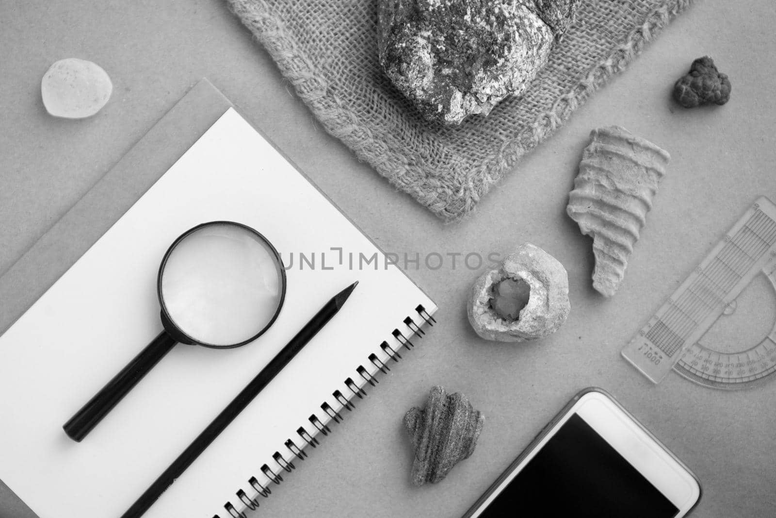 Stone samples, loop, notebook and mobile phome at geological laboratory. Geology rock laboratory. Laboratory for analysis of geological soil materials, stones, minerals, rocks samples for researchers