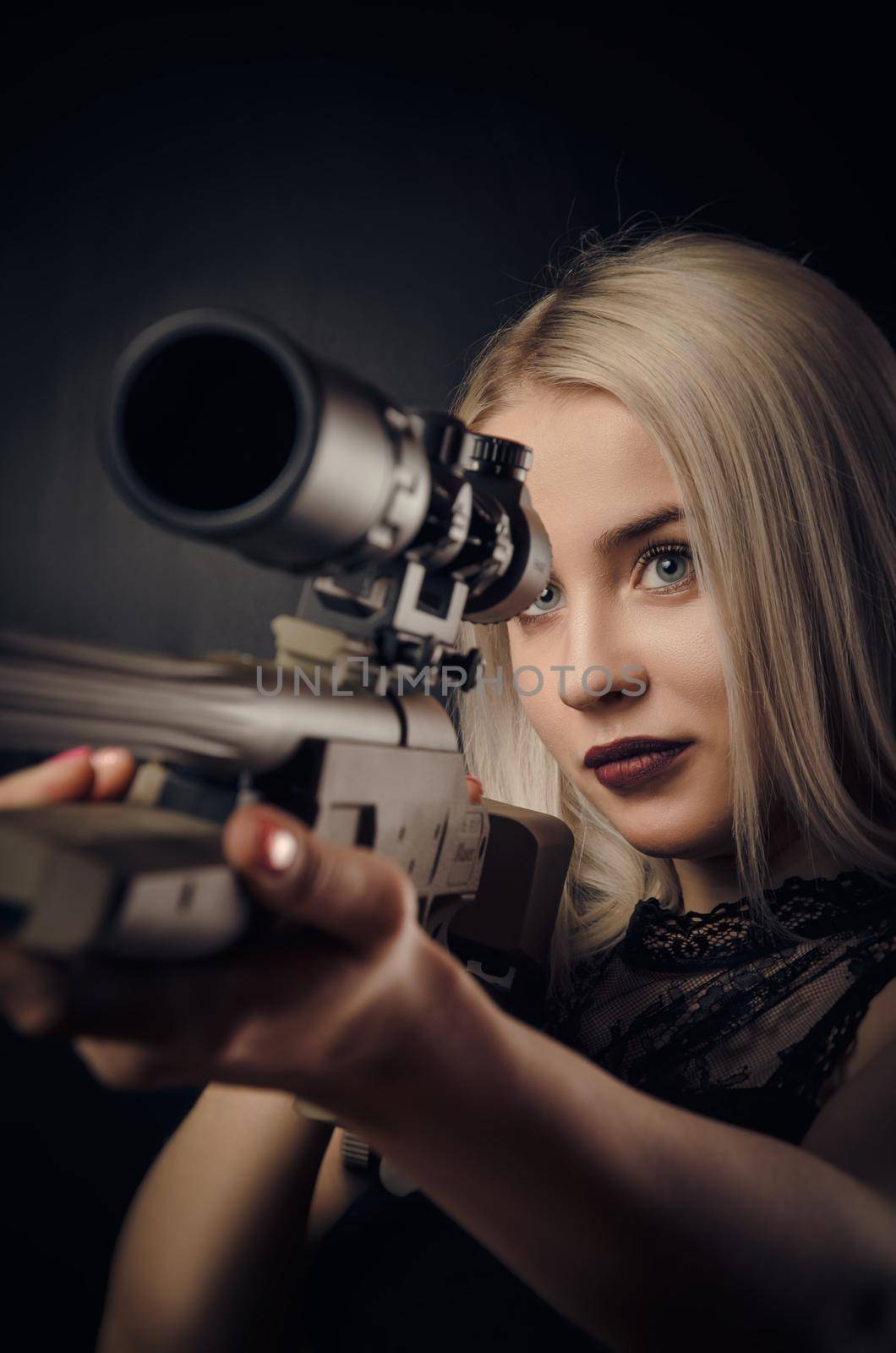 young blonde girl in black dress posing on black background with weapon by Rotozey