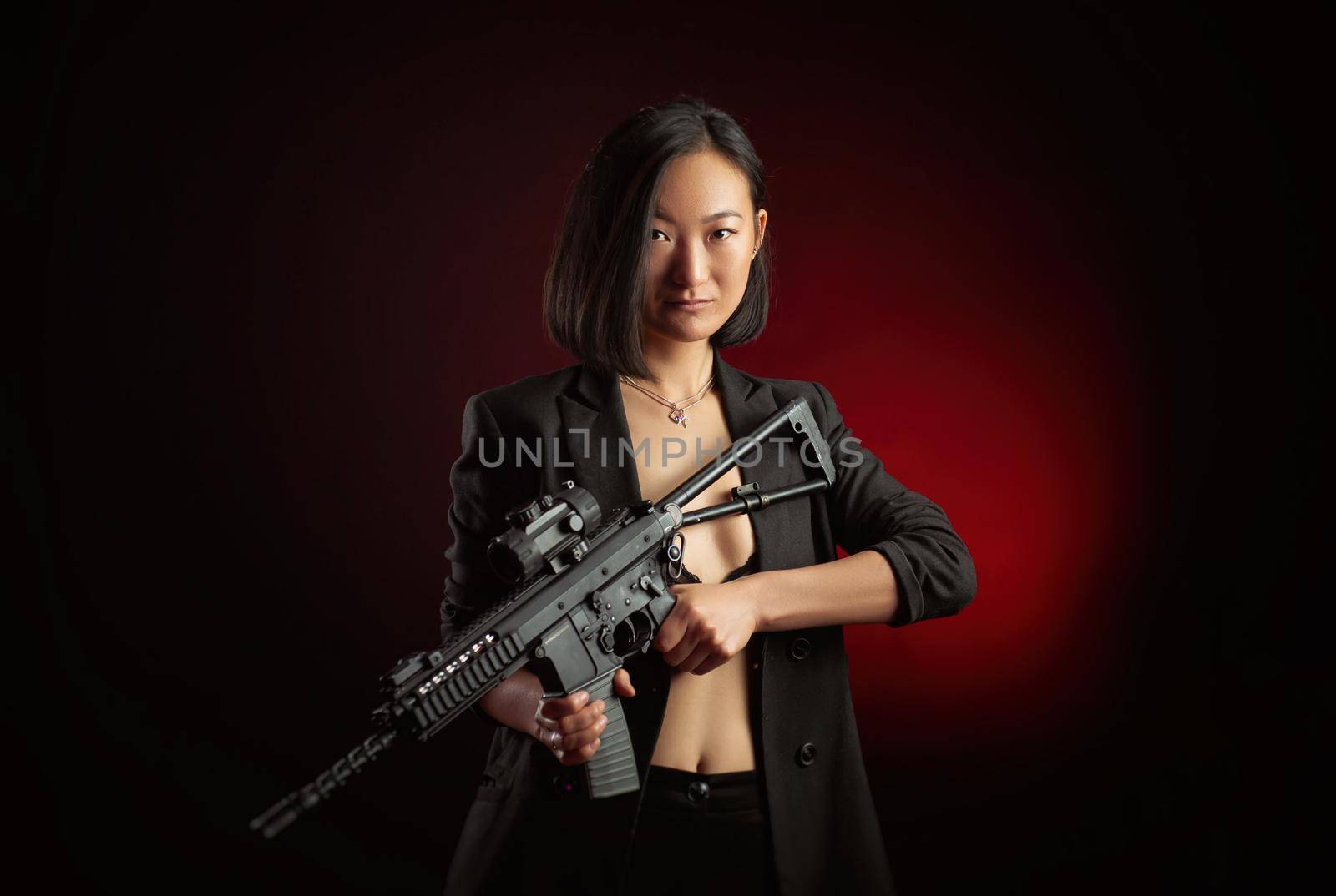 the asian woman in a jacket with an automatic rifle in her hands mafia fighter