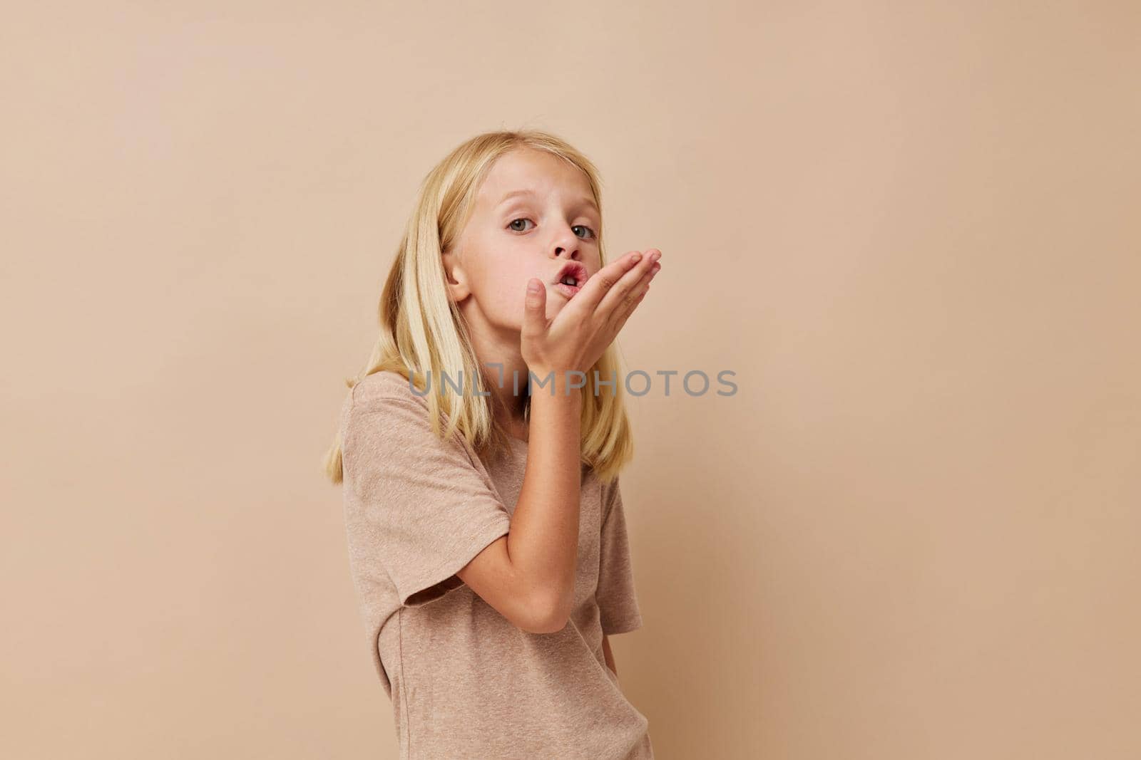 Positive little girl with blond hair isolated background. High quality photo