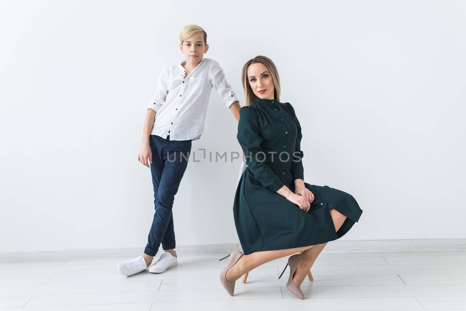 Parenting, family and single parent concept - A happy mother and teen son smiling on white background. by Satura86