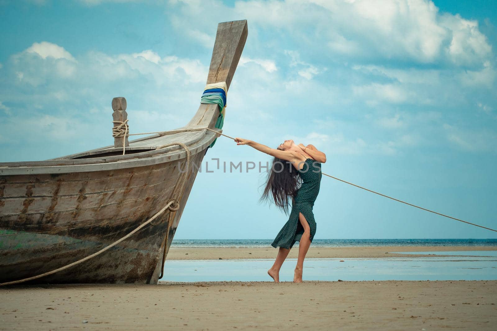the photo of a charming brunette long-haired woman on the ocean. Fashion and glam concept. Copy space