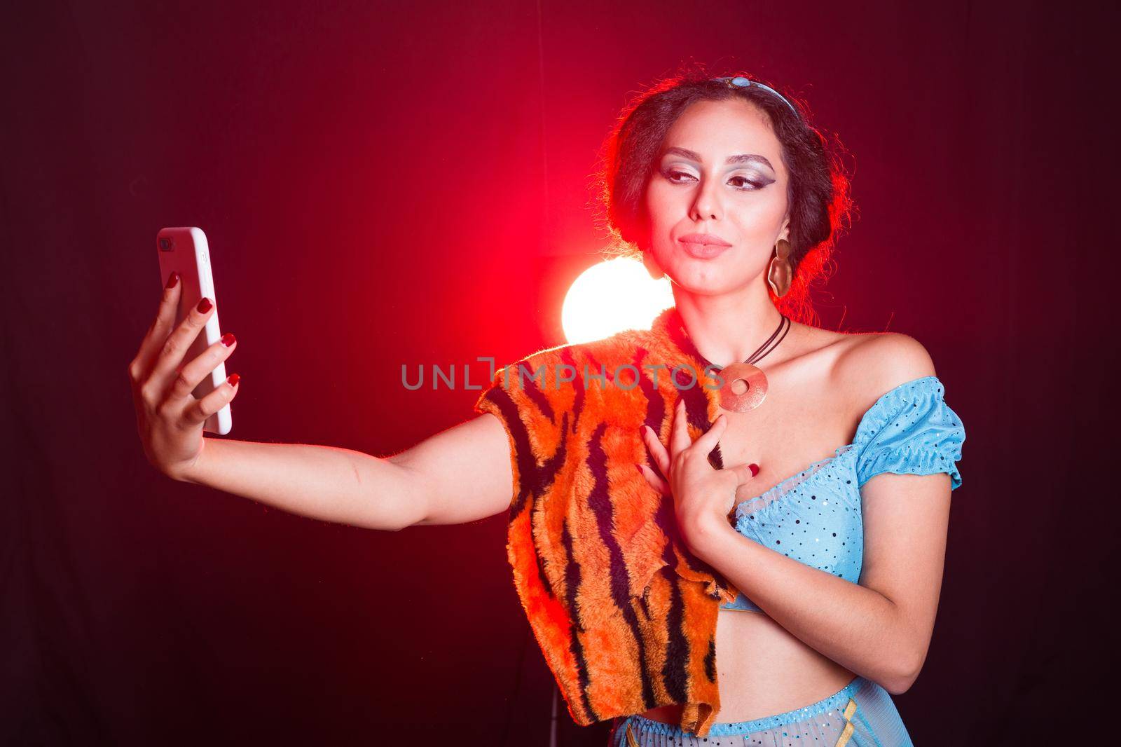 Girl doing selfie with tiger skin, crazy photos. Don't eco friendly lifestyle. Young woman takes pictures of herself in the phone. Life in social networks, narcissism, modern personality. by Satura86