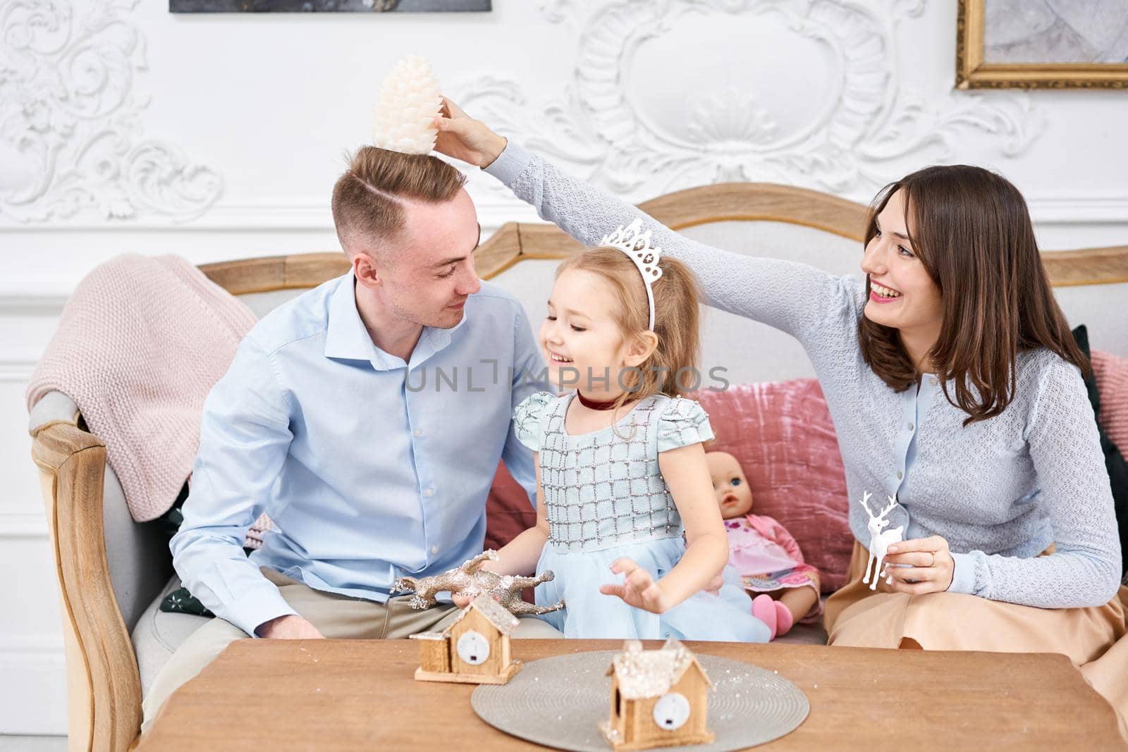 Loving family Mom and dad, little daughter . Parents and baby child having fun. Merry Christmas and Happy New Year. Cheerful pretty people. by Malkovkosta