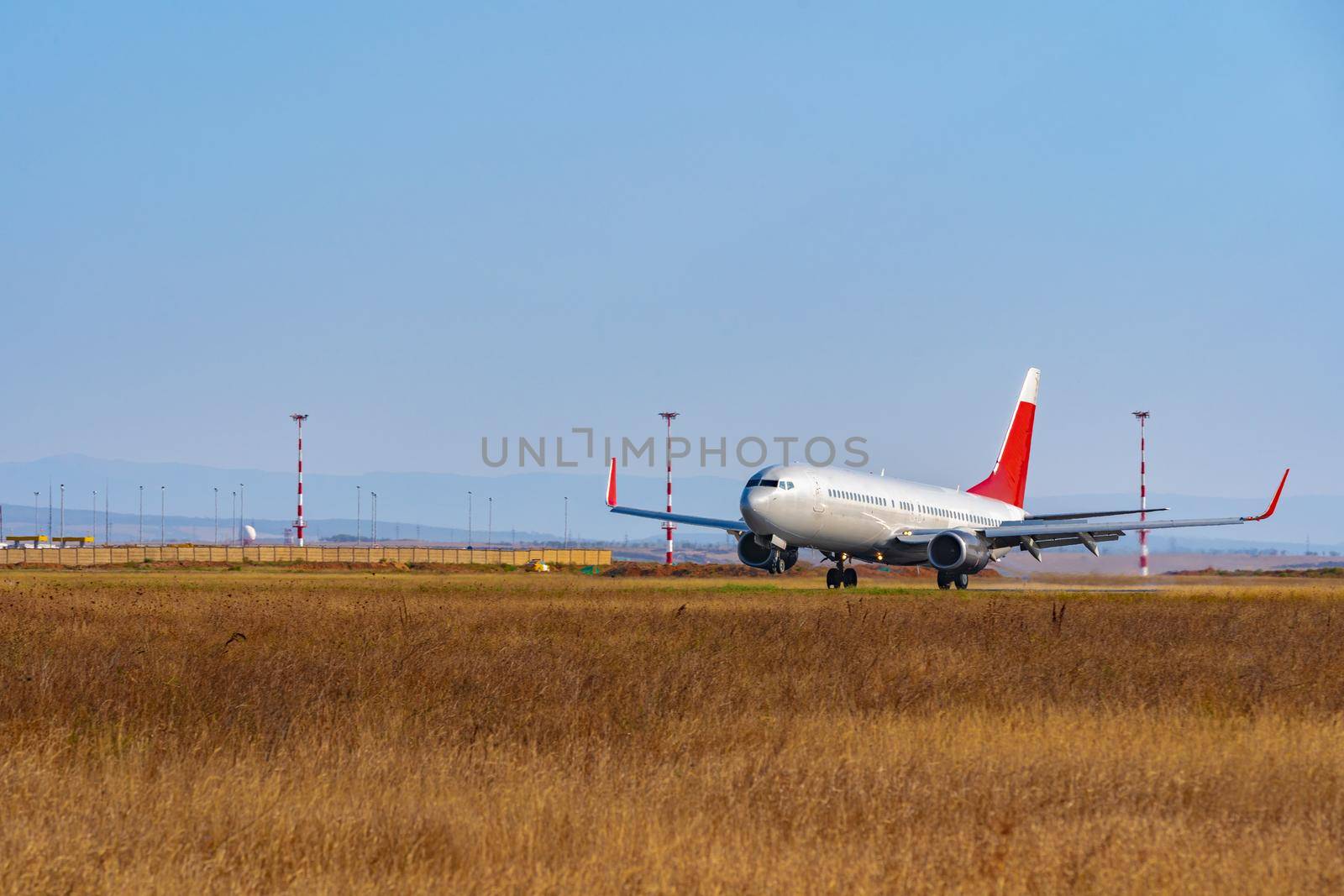 Passenger plane taking off from runway at airport on sunny day photo