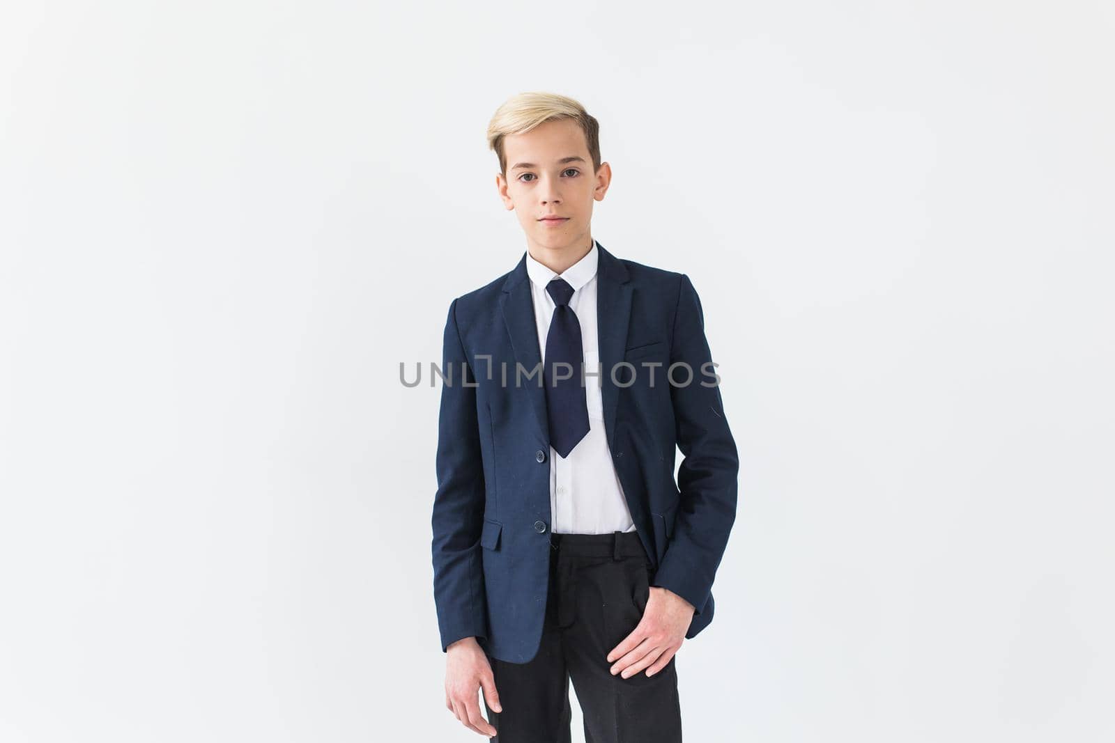 Portrait of stylish school boy teenager in white shirt and jacket against white background with copy space. by Satura86