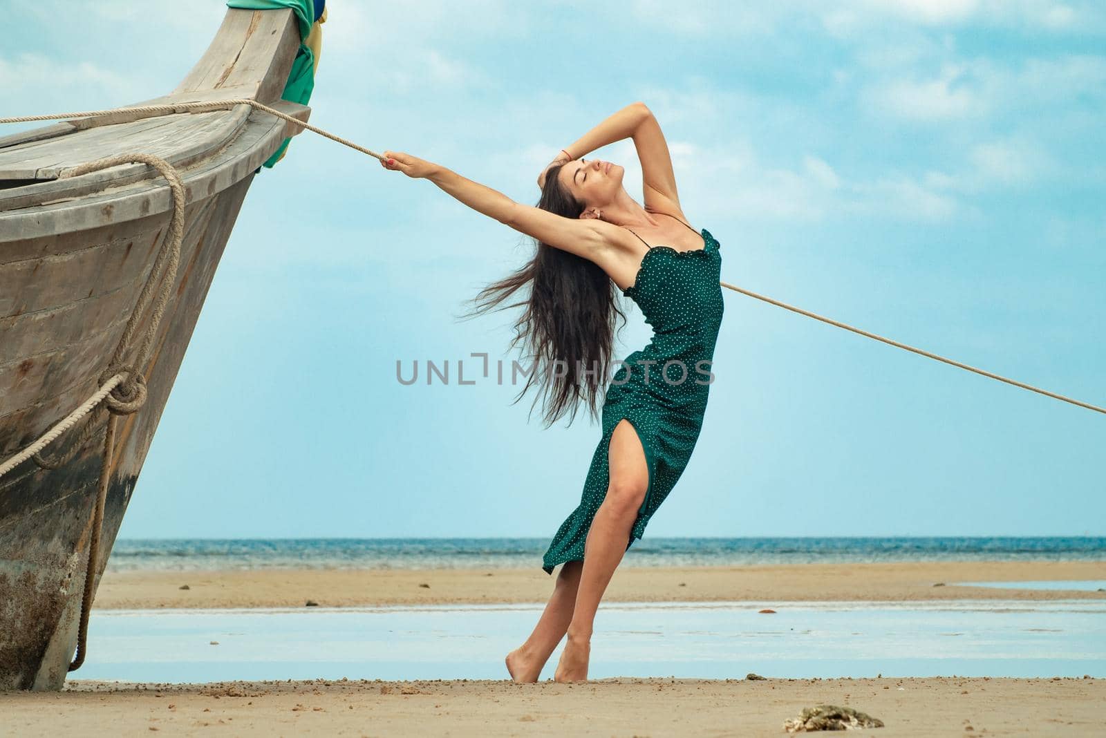 photo of a charming brunette long-haired woman on the ocean. Fashion and glam concept. Copy space by Rotozey