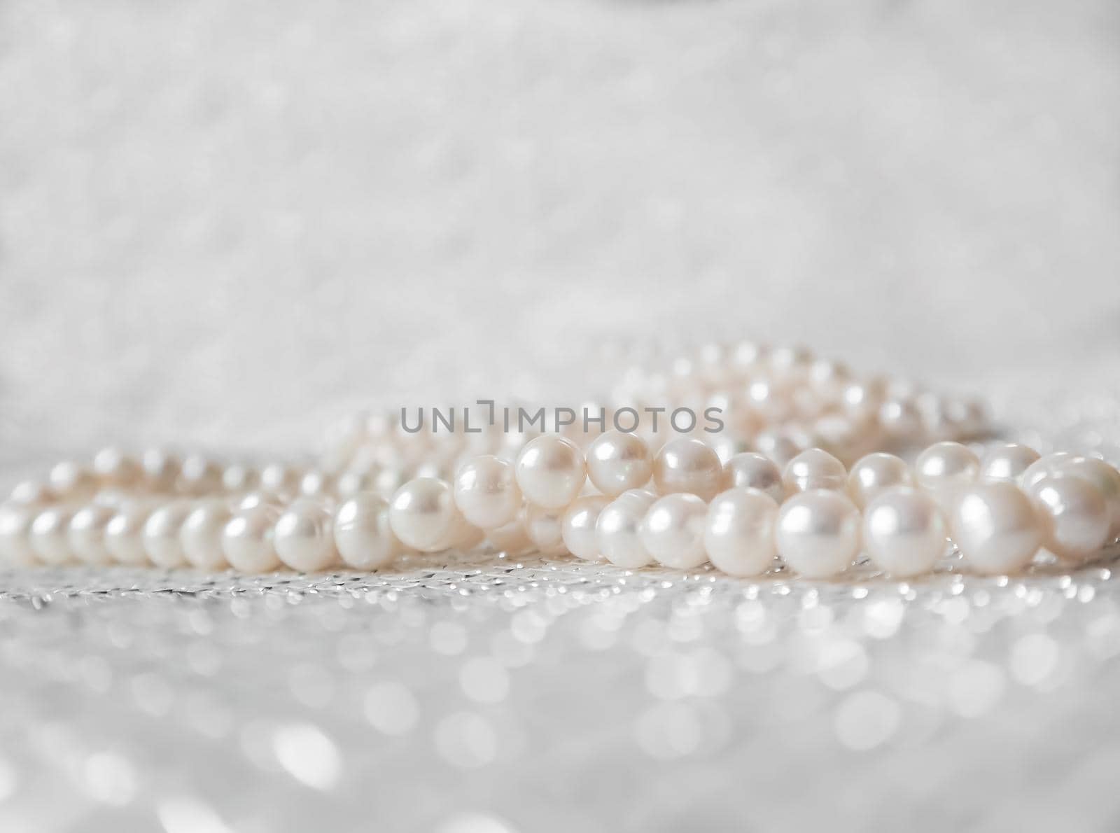 Nature white string of pearls on a sparkling background in soft focus, with highlights by Olayola