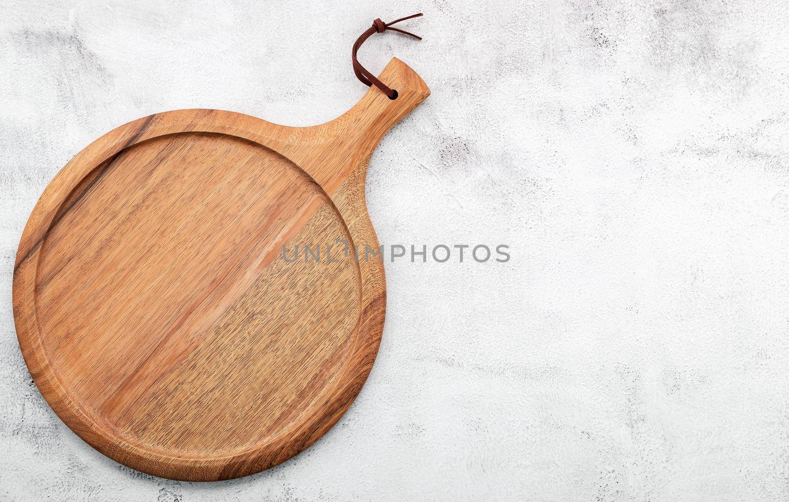 Empty wooden pizza platter set up on white concrete. Pizza board on white concrete background flat lay and copy space.