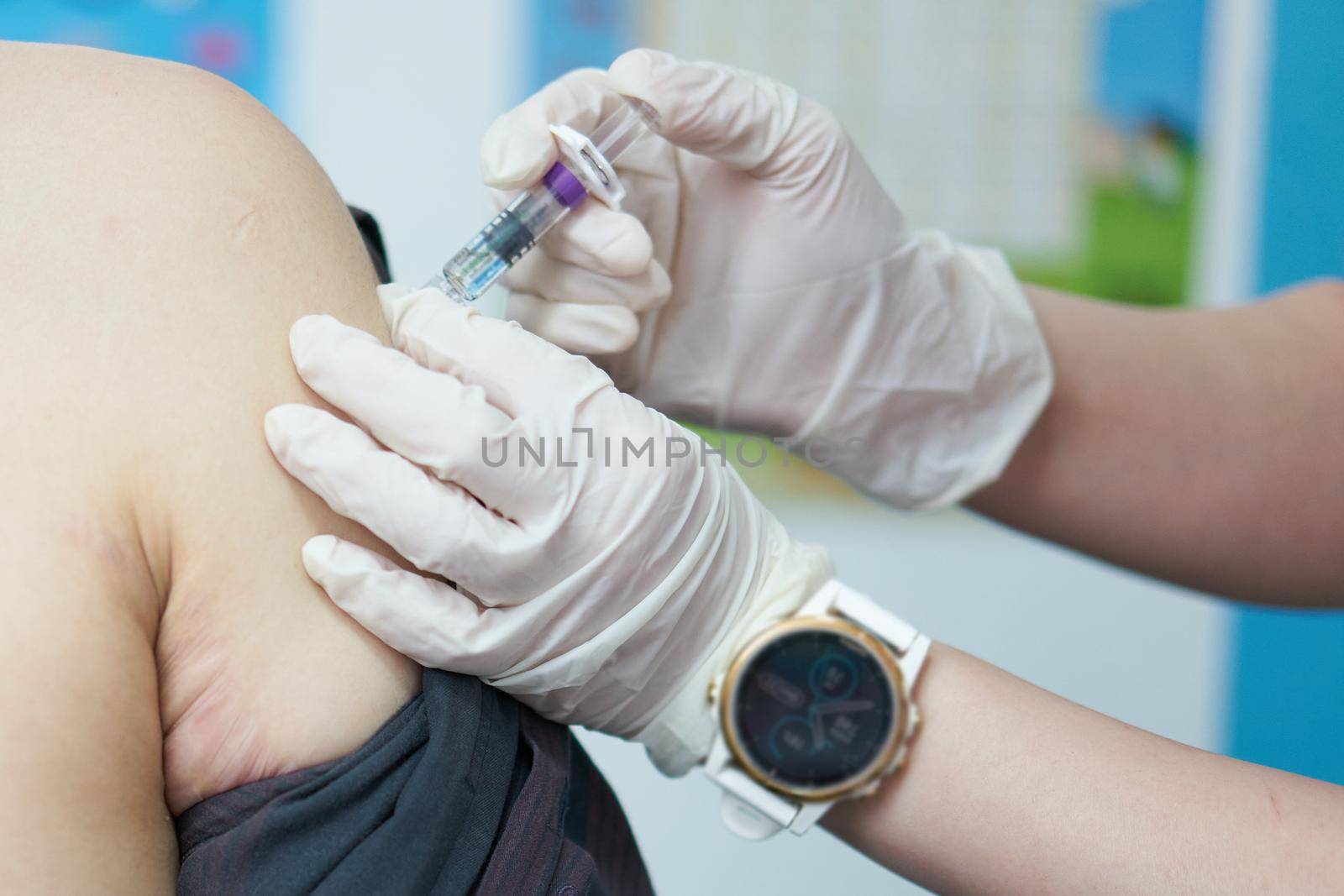 close up shot of doctor use vaccine inject for covid immunization at shoulder of asia man