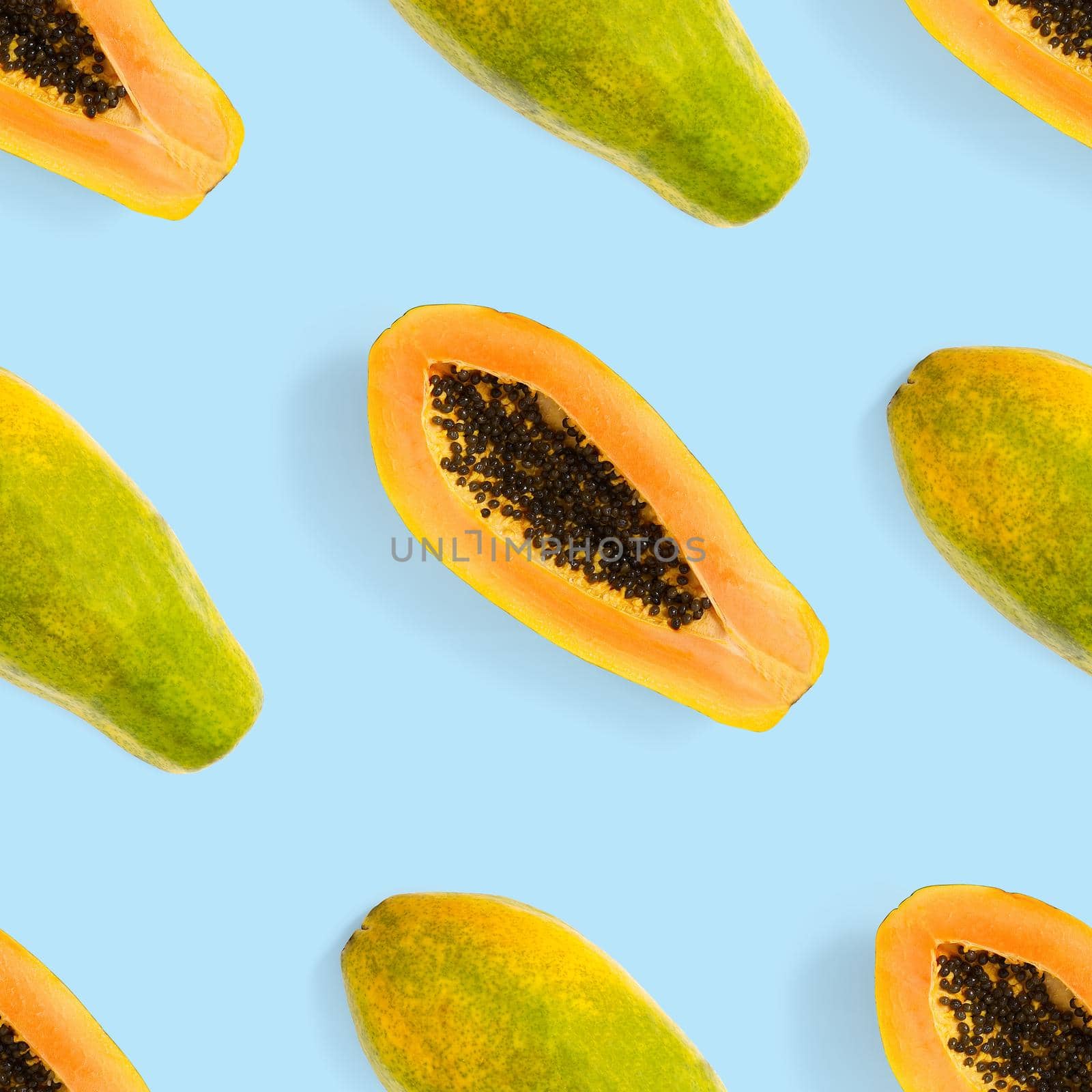 Fresh ripe papaya seamless pattern on blue background. Tropical abstract background. Top view. by PhotoTime