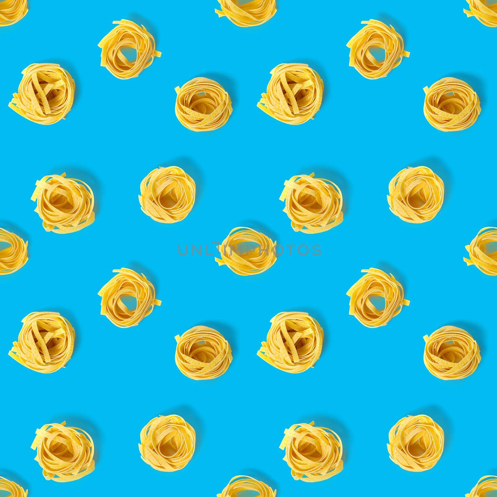 Seamless pattern from Italian tagliatelle pasta. raw pasta fettuccine, pop art background, flat lay. Italian raw nest pasta isolated on blue.