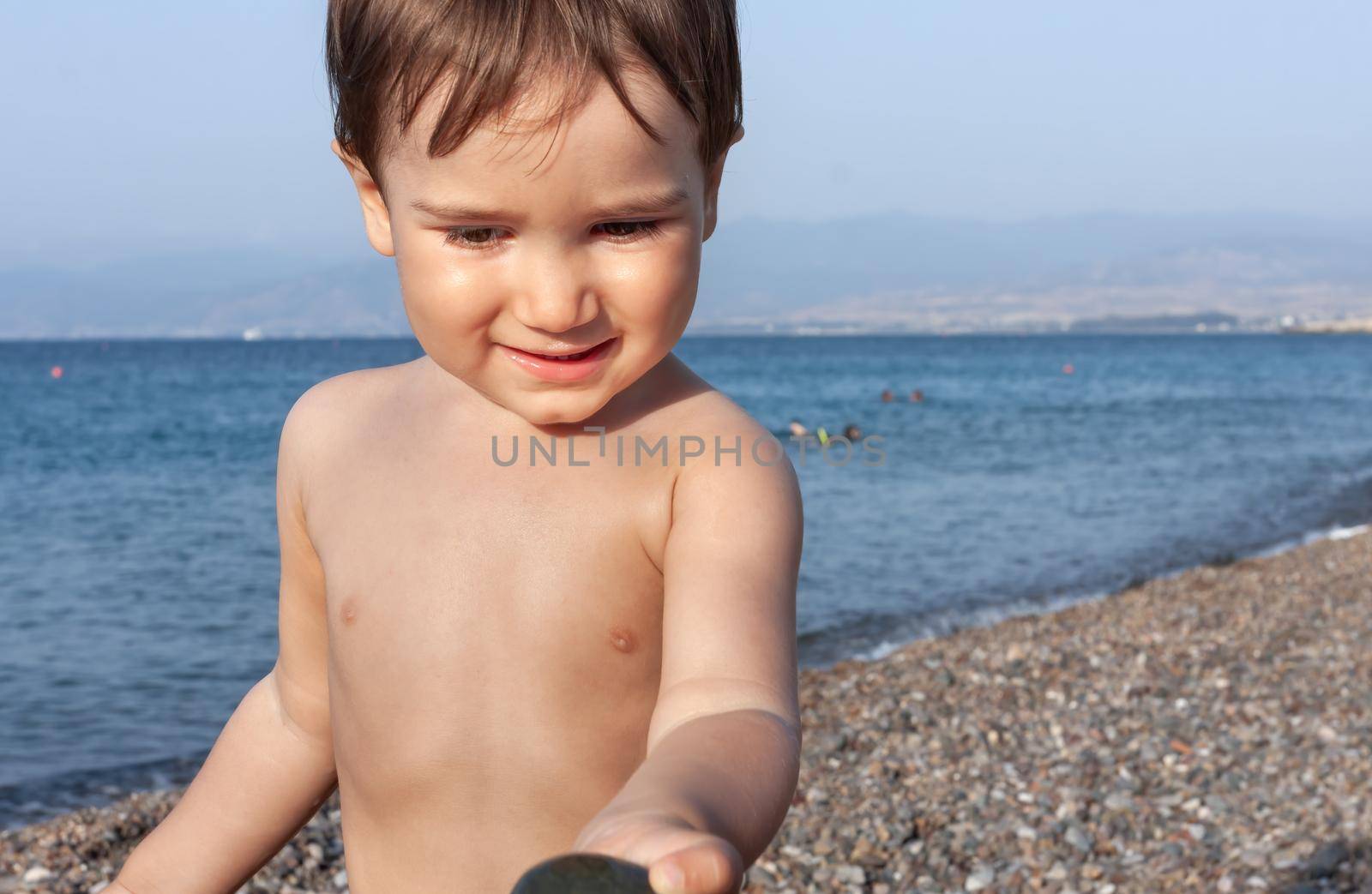 Healthy lifestyle. Little boy resting and having fun on a rocky beach on the Mediterranean coast