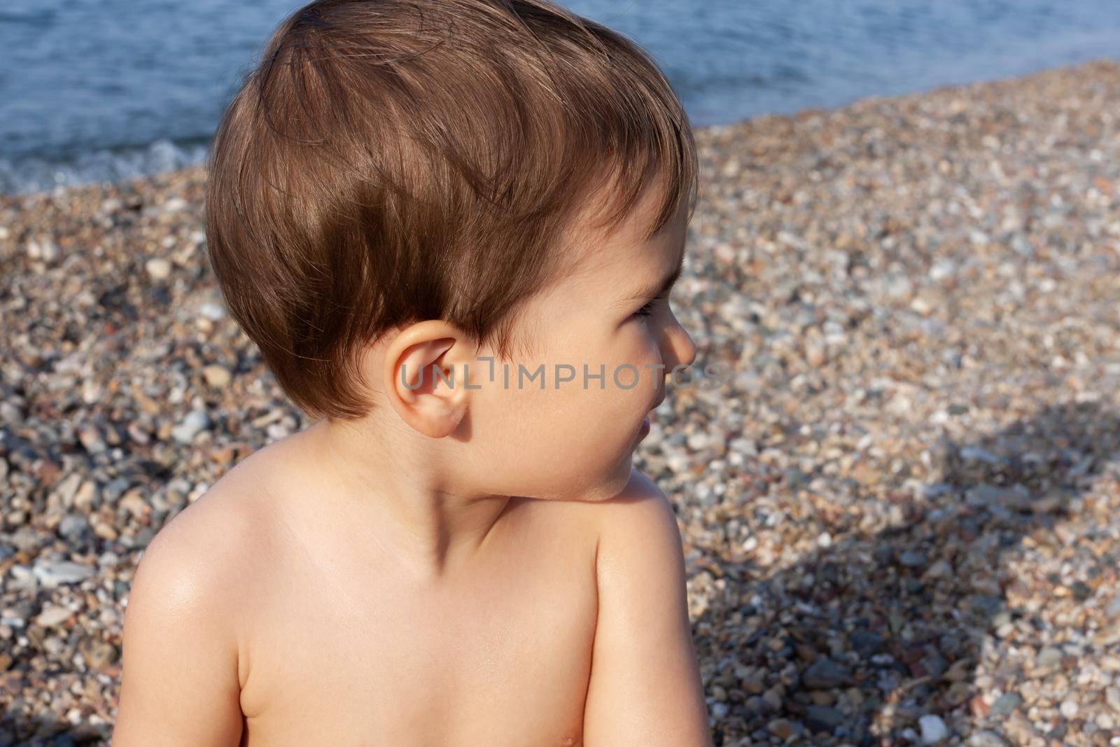 Healthy lifestyle. Little boy resting and having fun on a rocky beach on the Mediterranean coast