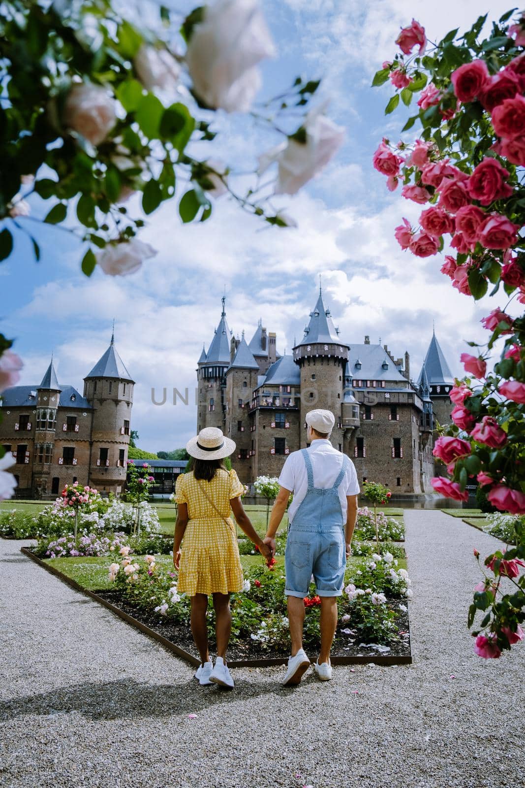 Castle de Haar Utrecht, couple men and woman mid age European and Asian visit De Haar Castle in Dutch Kasteel de Haar is located in Utrecht Netherlands during Spring with flowers in the garden