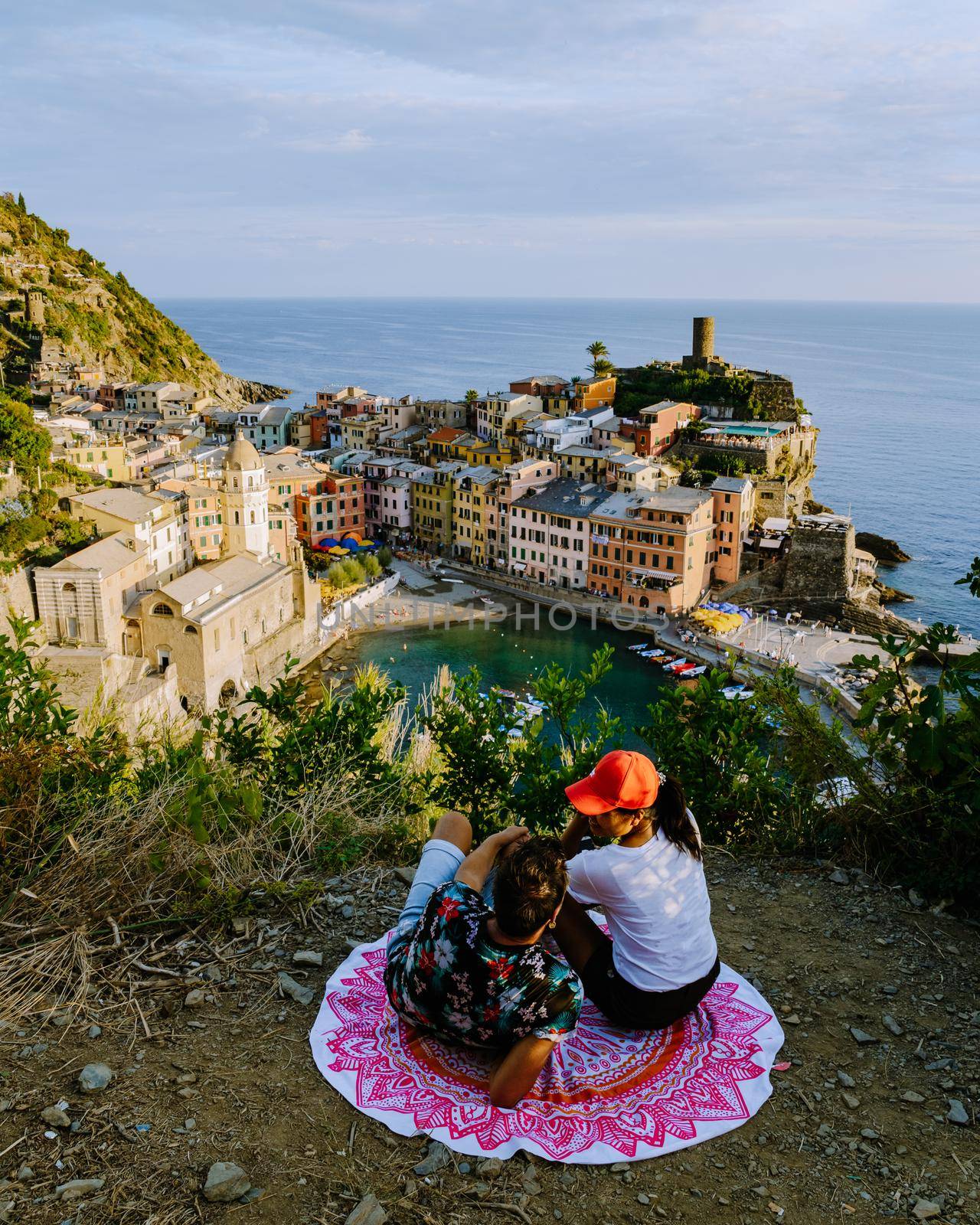 Cinque Terre, Italy, The picturesque coastal village of Vernazza, Cinque Terre, Italy, couple man, and woman European men and Asian woman watching the sunset at Vernazza Cinque Terre Italy