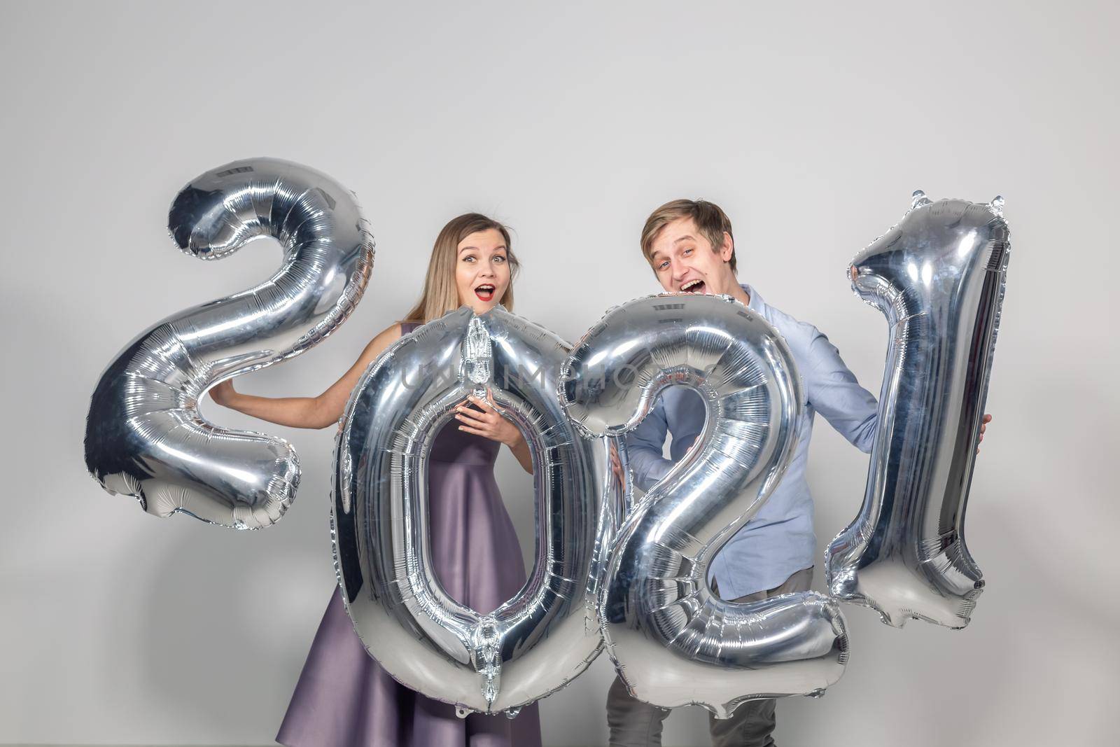 Party, people and new year holidays concept - woman and man celebrating new years eve 2021.