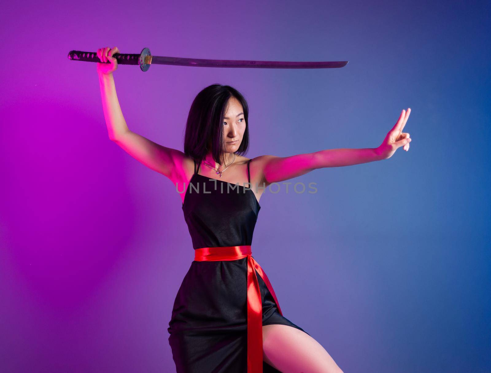 the slender Asian woman in a black dress with a katana in her hand image of a samurai on a neon background