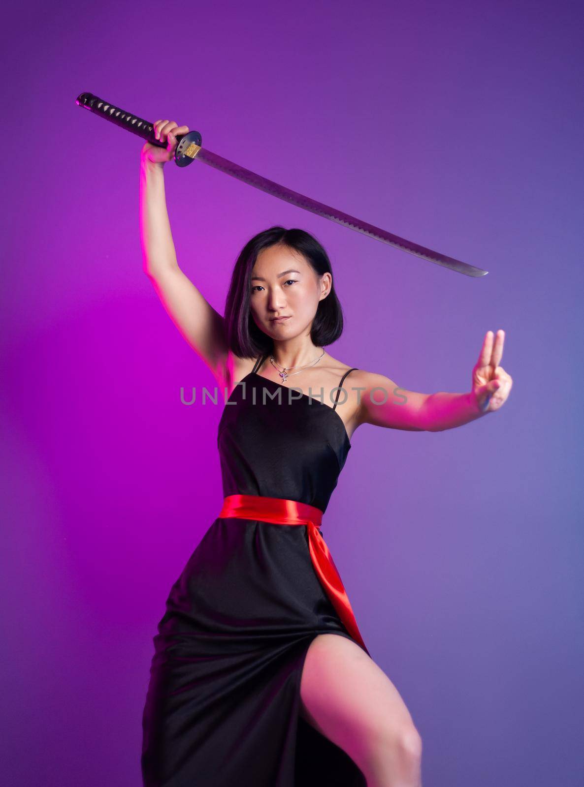 the slender Asian woman in a black dress with a katana in her hand image of a samurai on a neon background