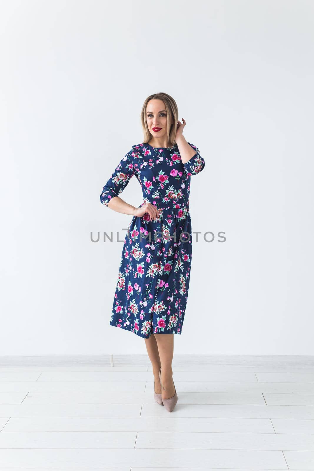 Fashionable young woman in beautiful dress posing at studio. Isolated over white.