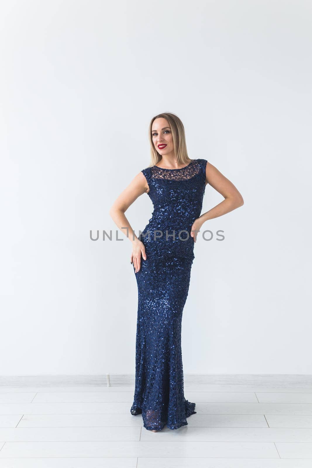 Fashionable young woman in beautiful dress posing at studio. Isolated over white.