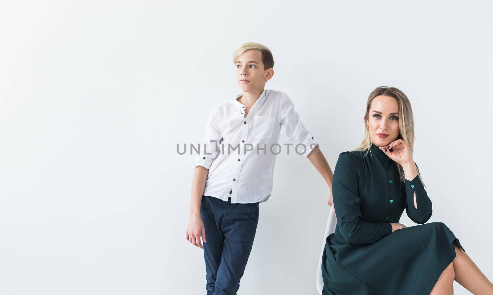 Parenting, family and single parent concept - A happy mother and teen son smiling on white background with copy space. by Satura86