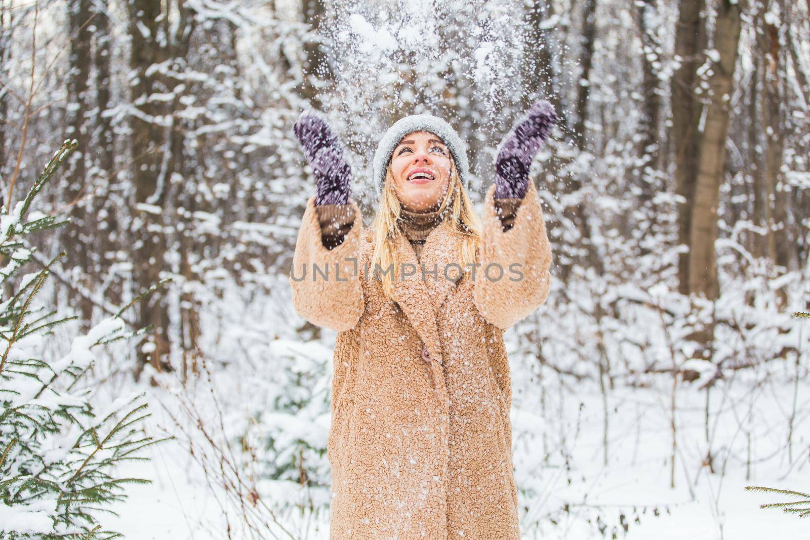 Woman throws up snow, fun and winter concept. by Satura86