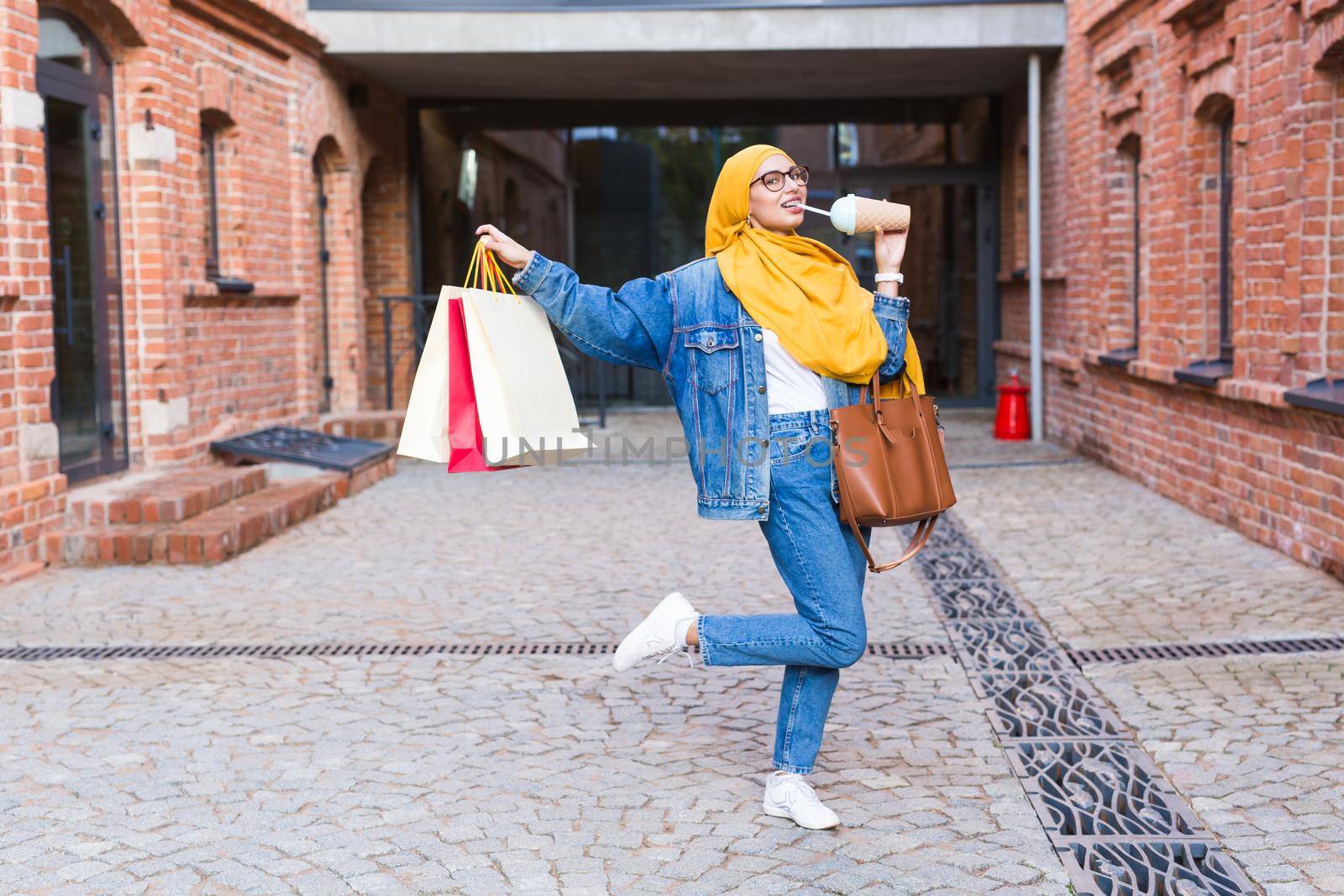 Sale and buying concept - Happy arab muslim girl with shopping bags after mall by Satura86