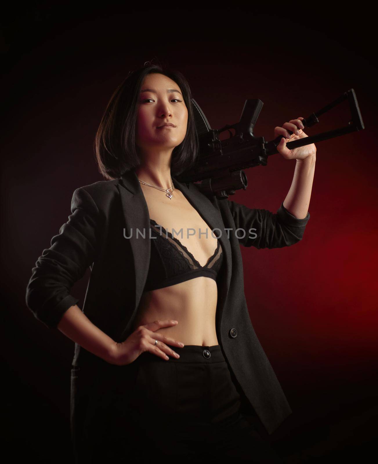 the asian woman in a jacket with an automatic rifle in her hands mafia fighter