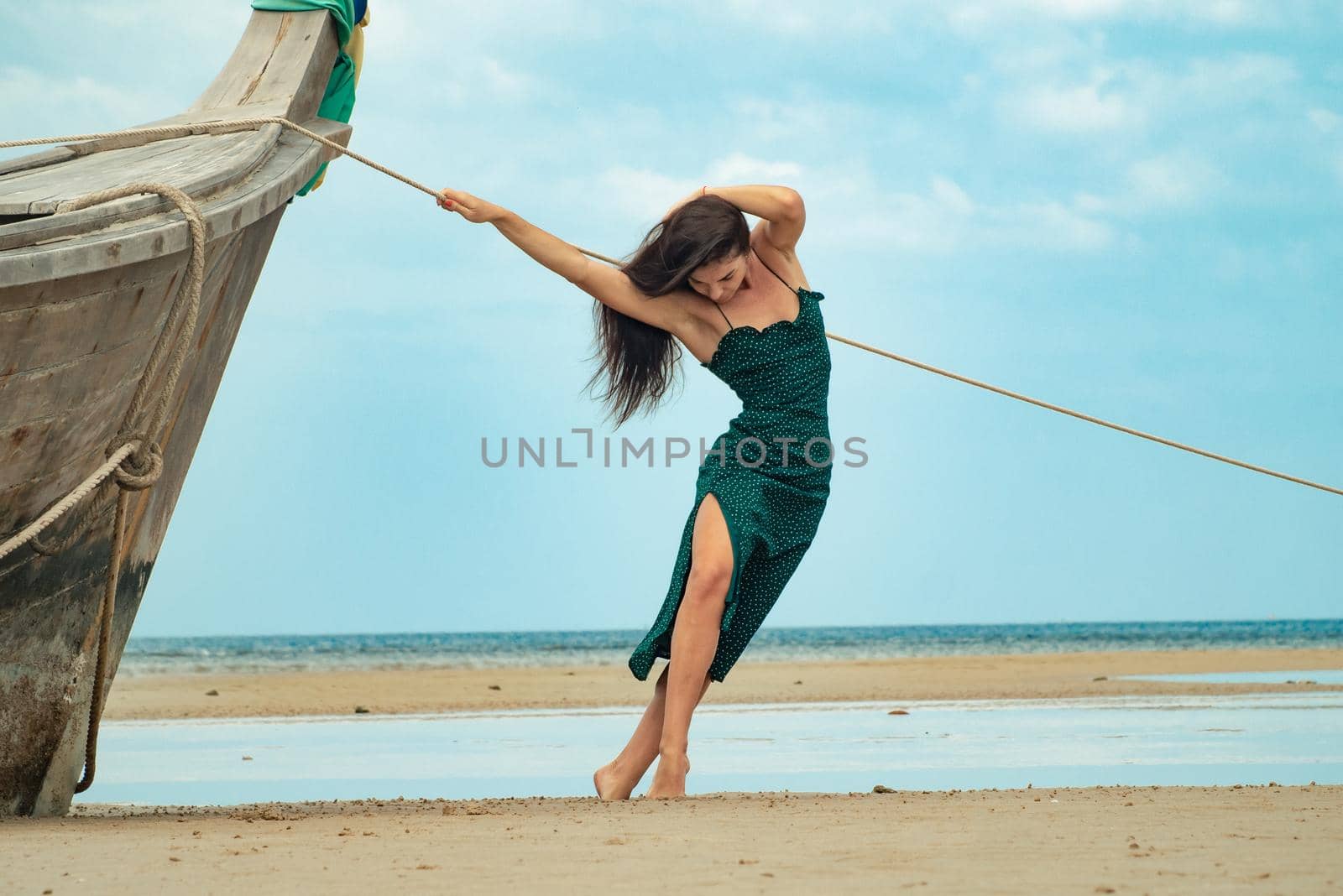 the photo of a charming brunette long-haired woman on the ocean. Fashion and glam concept. Copy space