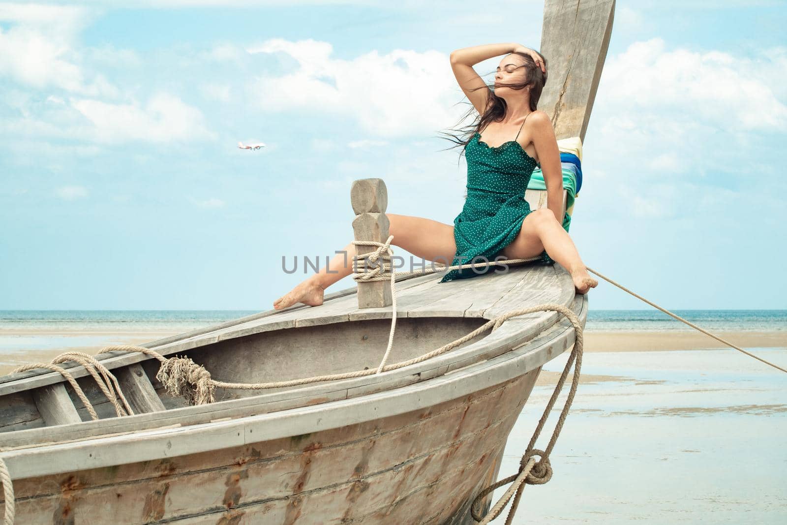 the photo of a charming brunette long-haired woman on the ocean. Fashion and glam concept. Copy space