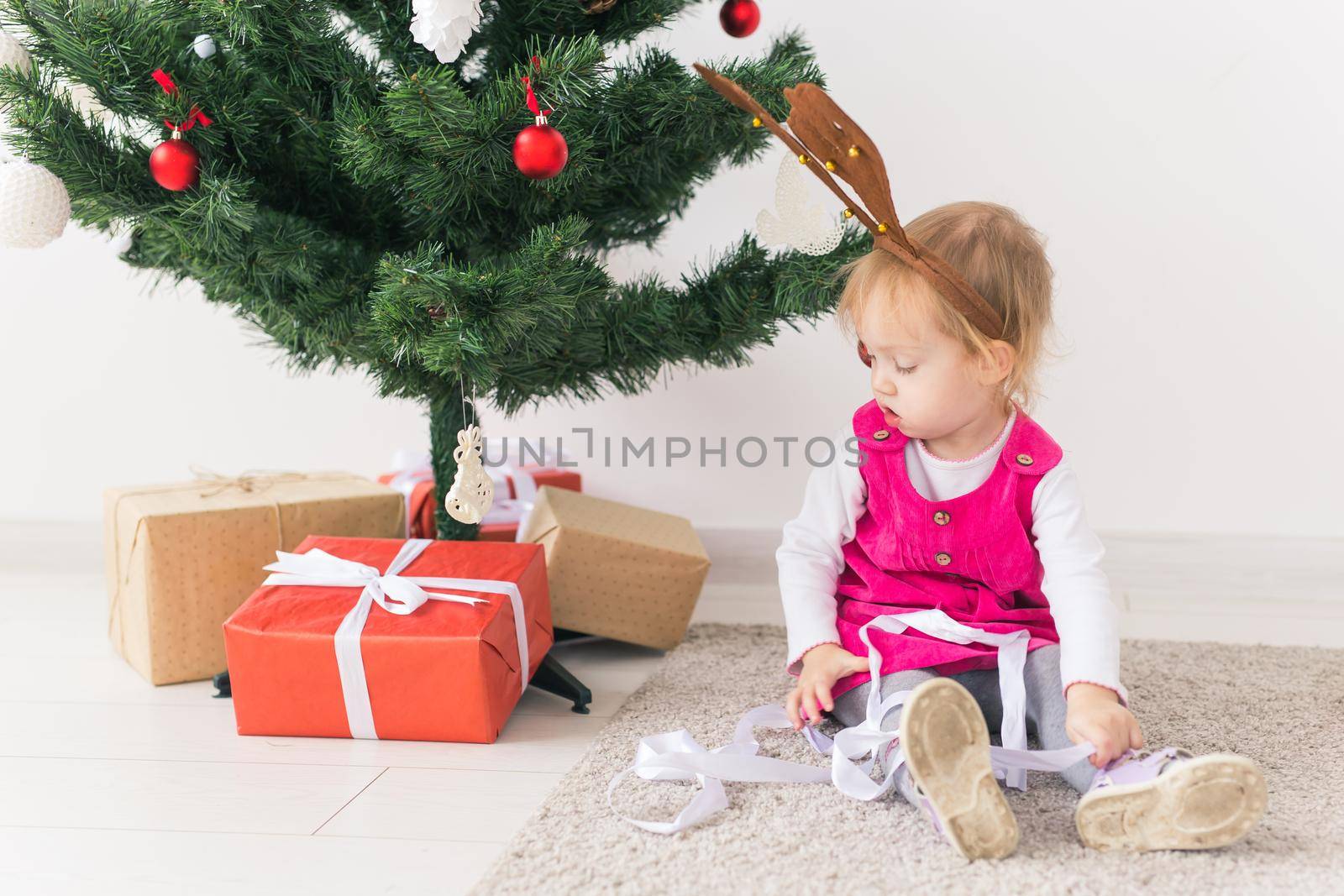 Child holding Christmas gift. Kid having fun at home. Xmas winter holiday concept by Satura86