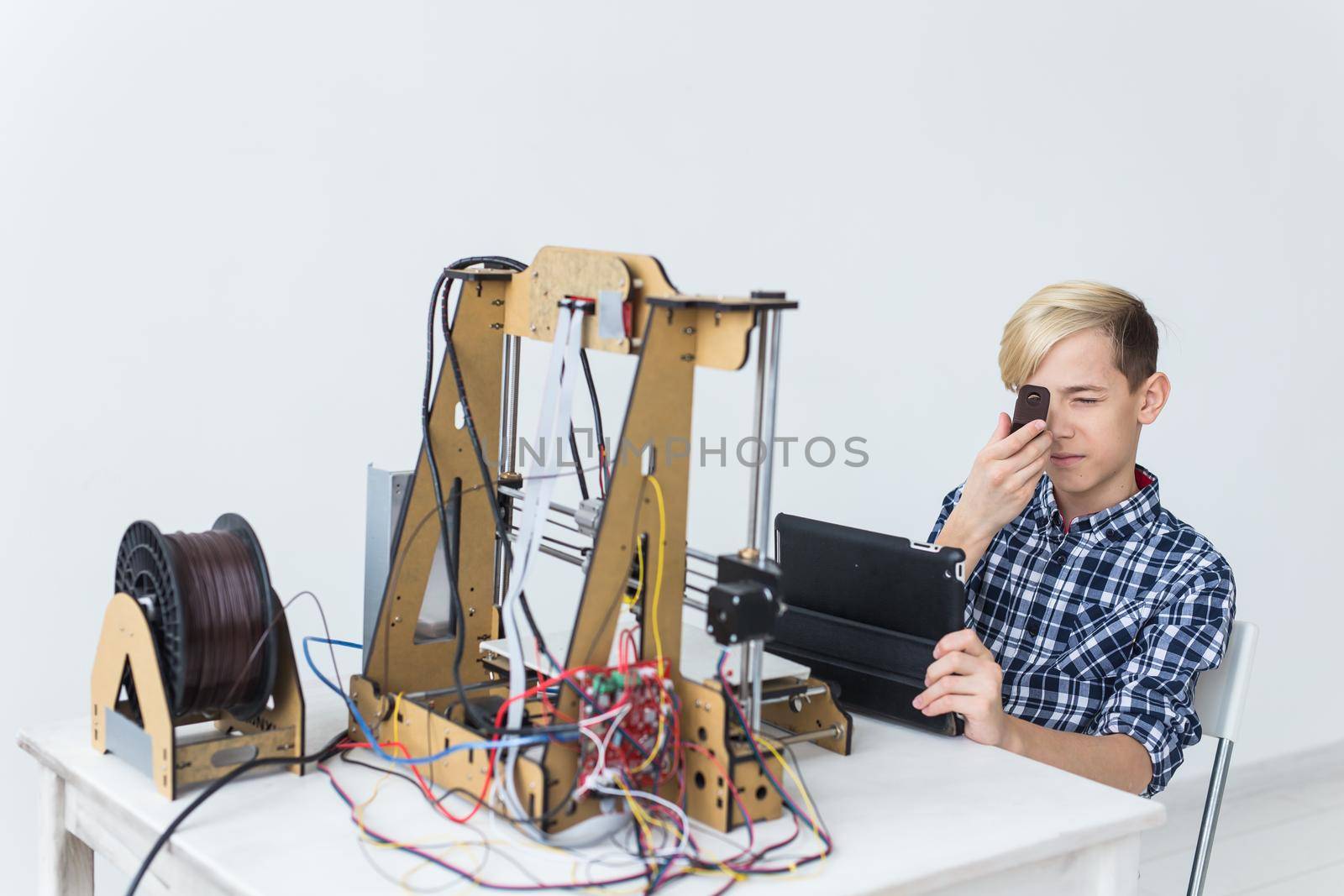 Education, children, technology concept - teen boy is printing on 3d printer. by Satura86
