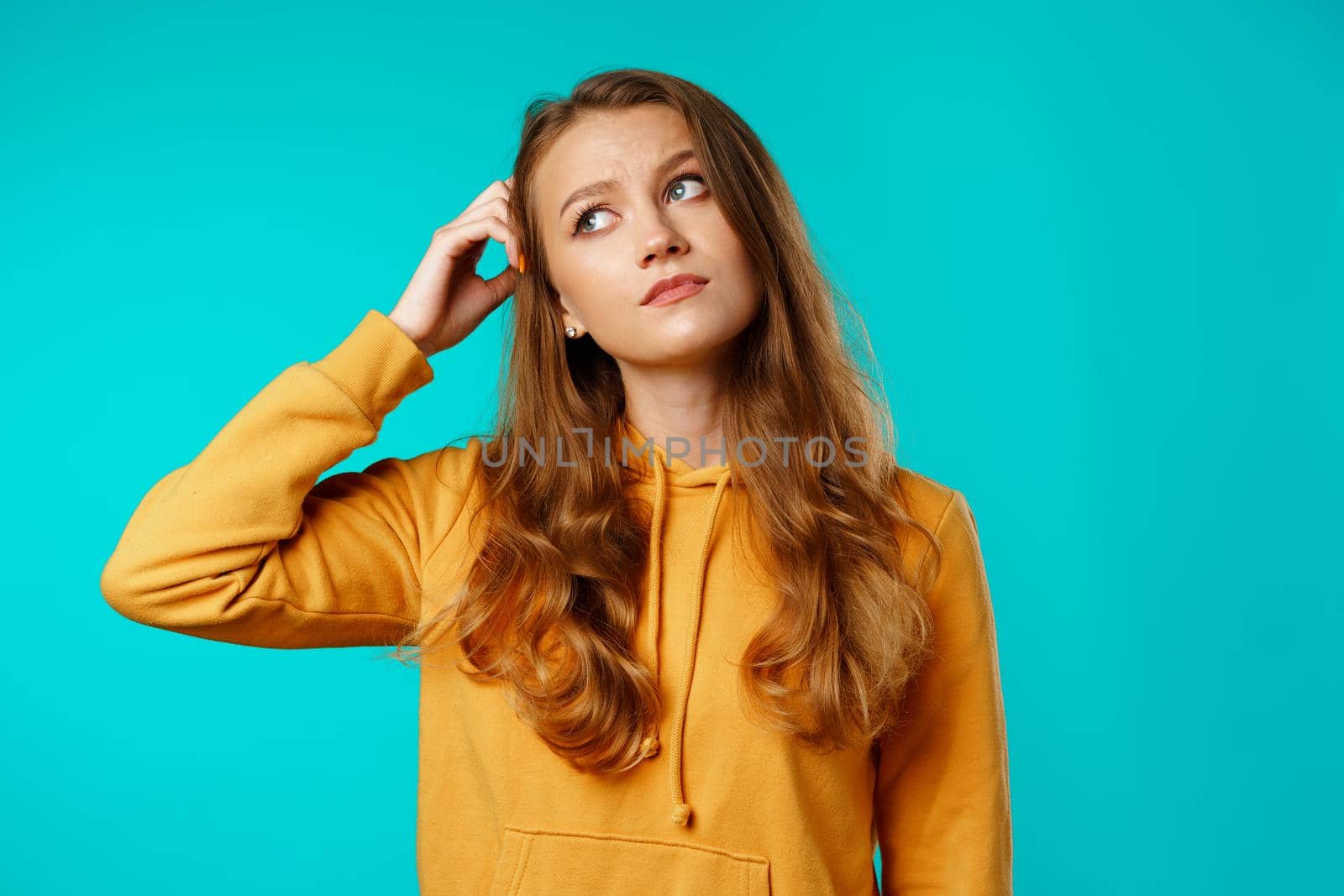 Studio portrait of beautiful young casual woman thinking about something