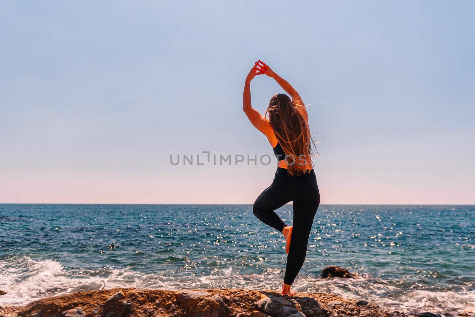Group of young womans fitness instructor in Sportswear Leggings and Tops, stretching in the gym before pilates, on a yoga mat near the large window on a sunny day, female fitness yoga routine concept.
