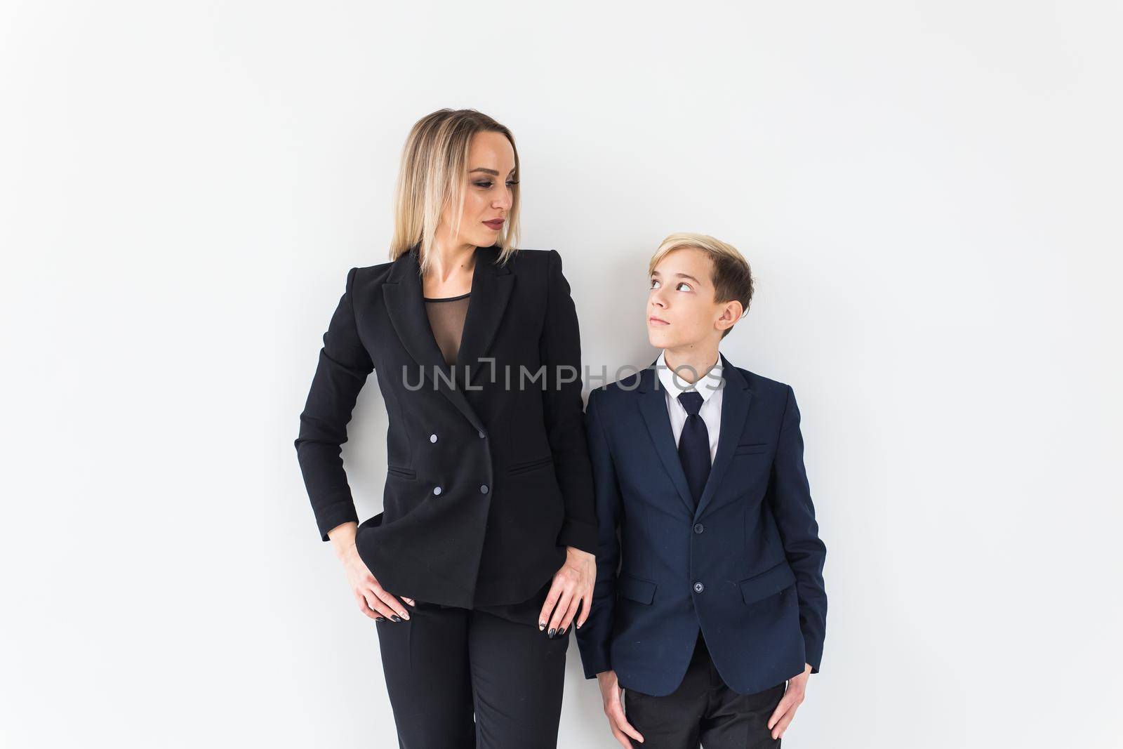 Teenager and single parent - Young mother and son standing together on white background. by Satura86