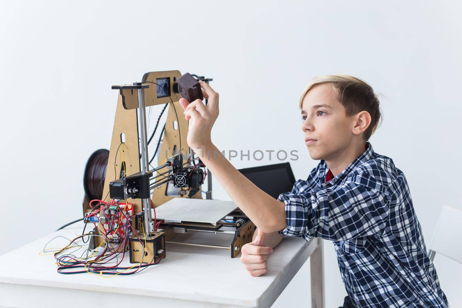 Education, children, technology concept - teen boy is printing on 3d printer. by Satura86