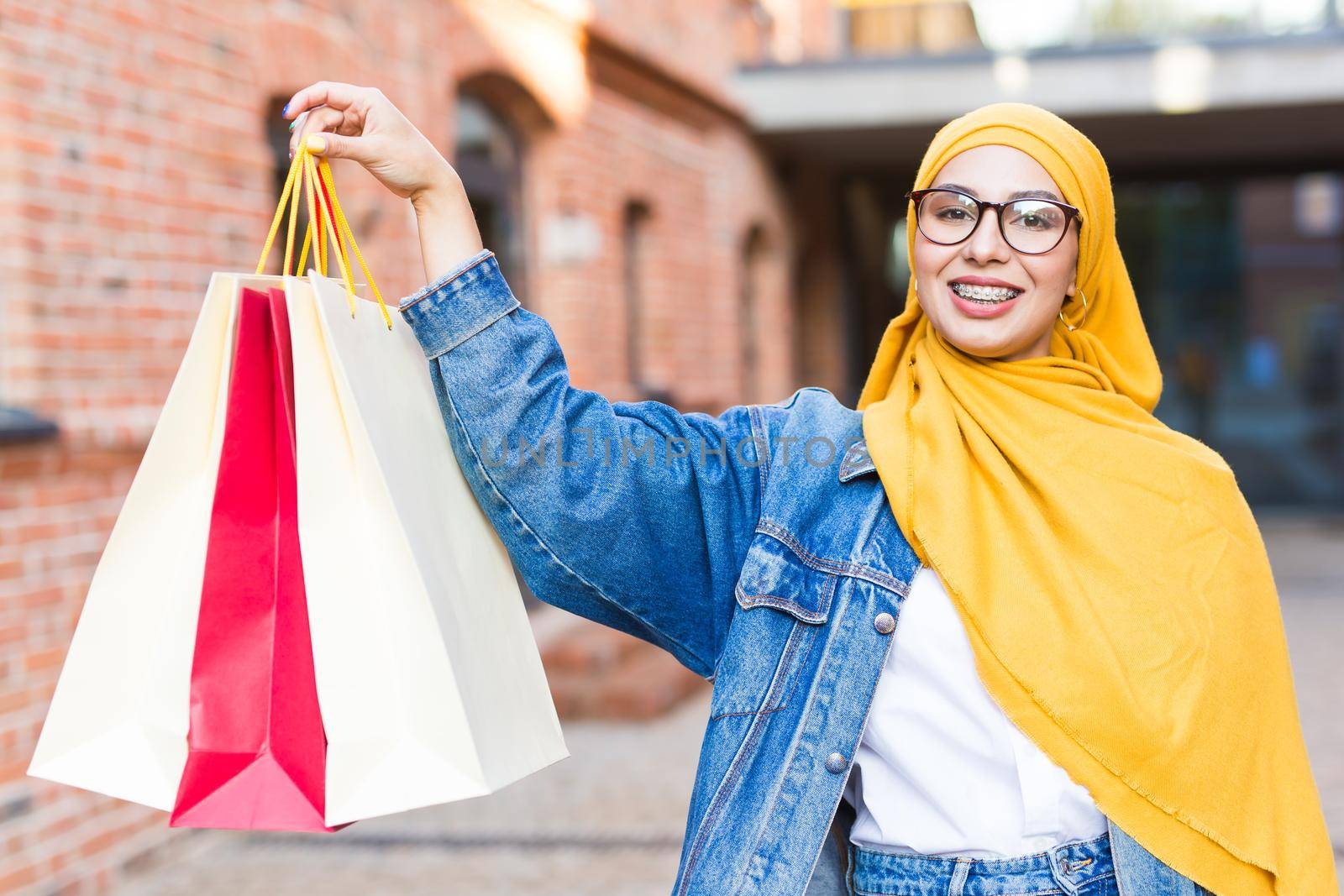 Sale and buying concept - Happy arab muslim girl with shopping bags after mall by Satura86