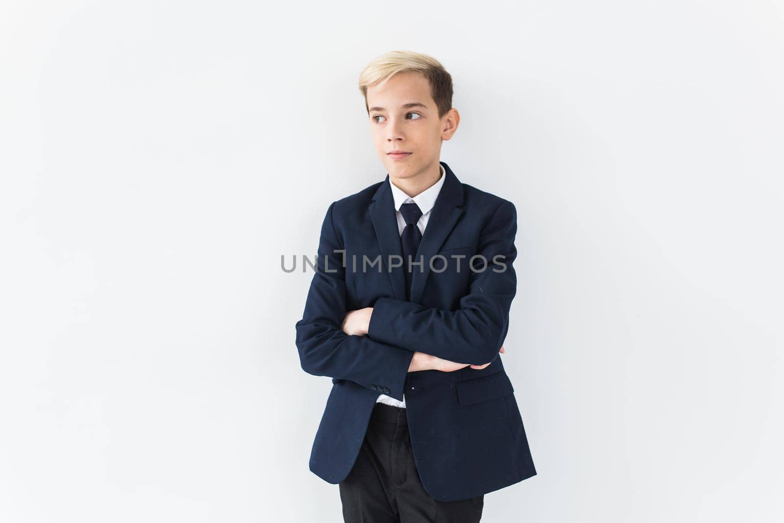 Portrait of stylish school boy teenager in white shirt and jacket against white background with copy space. by Satura86