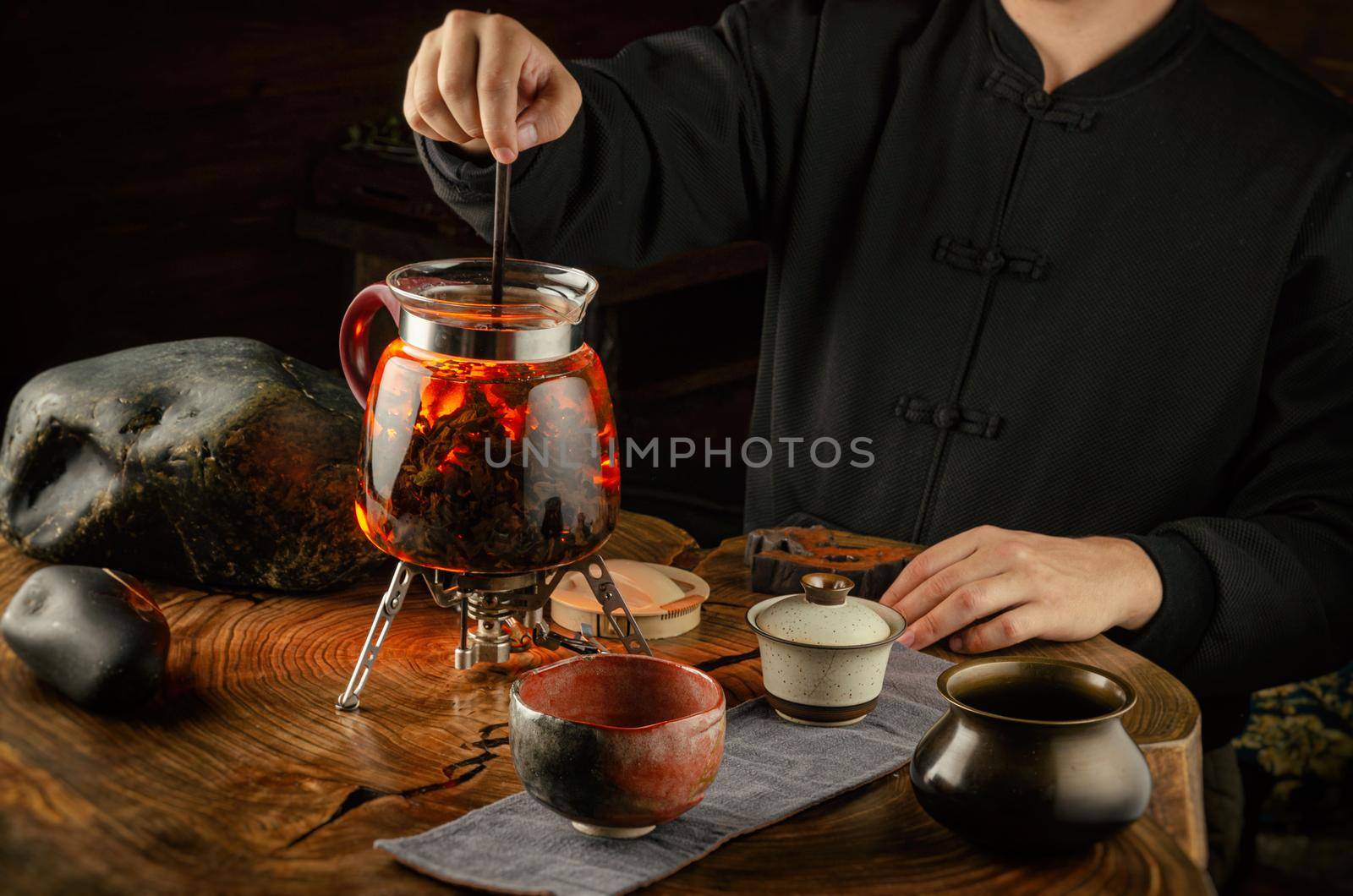 tea ceremony brewing tea on fire in a glass teapot by Rotozey