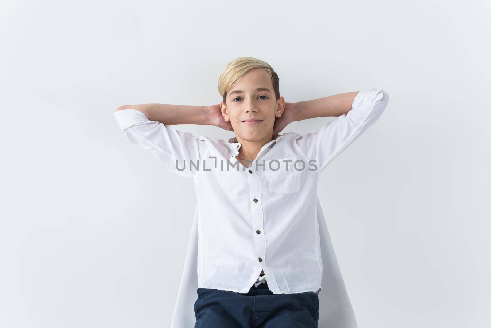 Solitude, loneliness and boredom concept - Bored teen student sitting in a school chair isolated on white