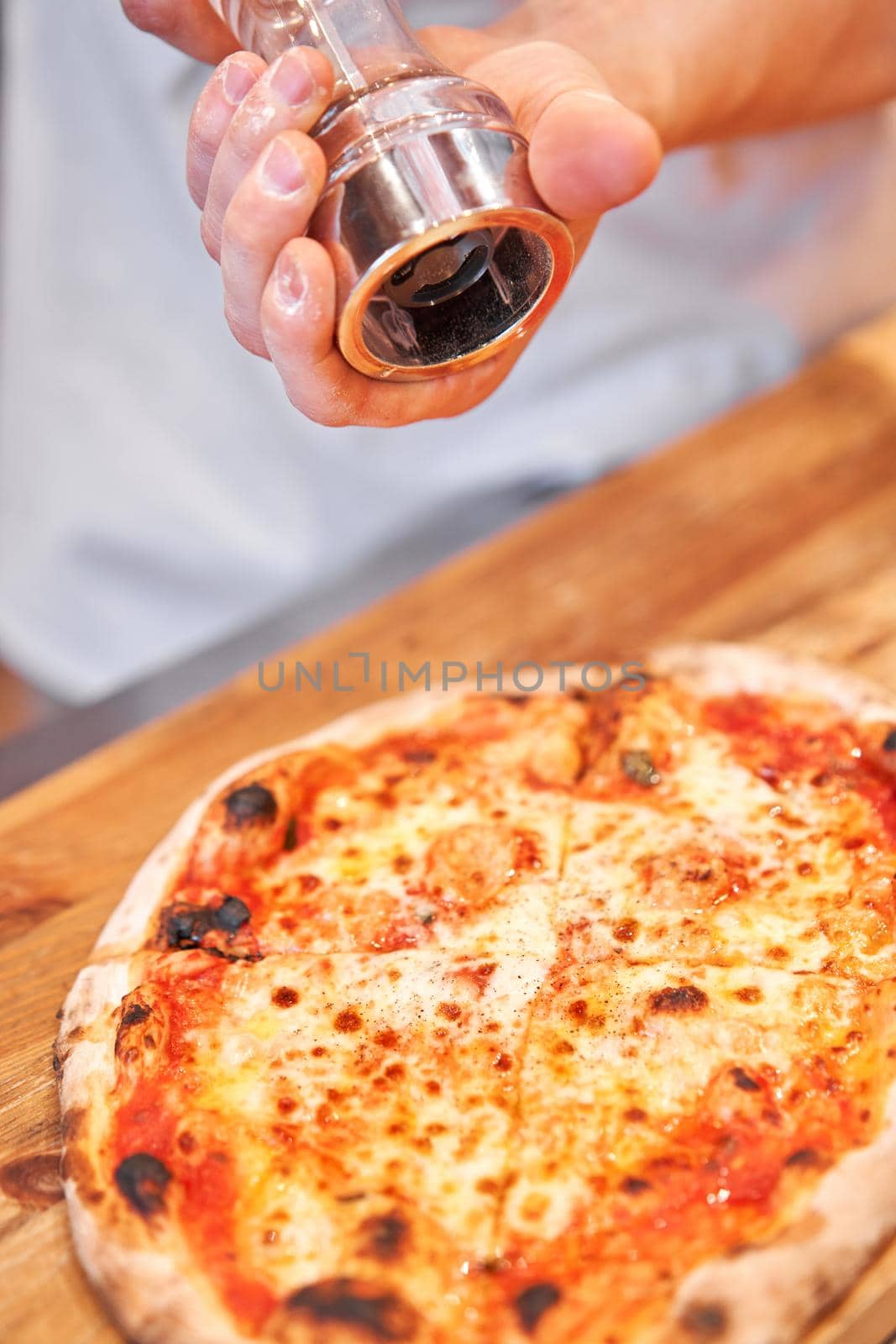 Pizza Margarita. Baked tasty margherita pizza in Traditional wood oven in Neapolitan restaurant, Italy
