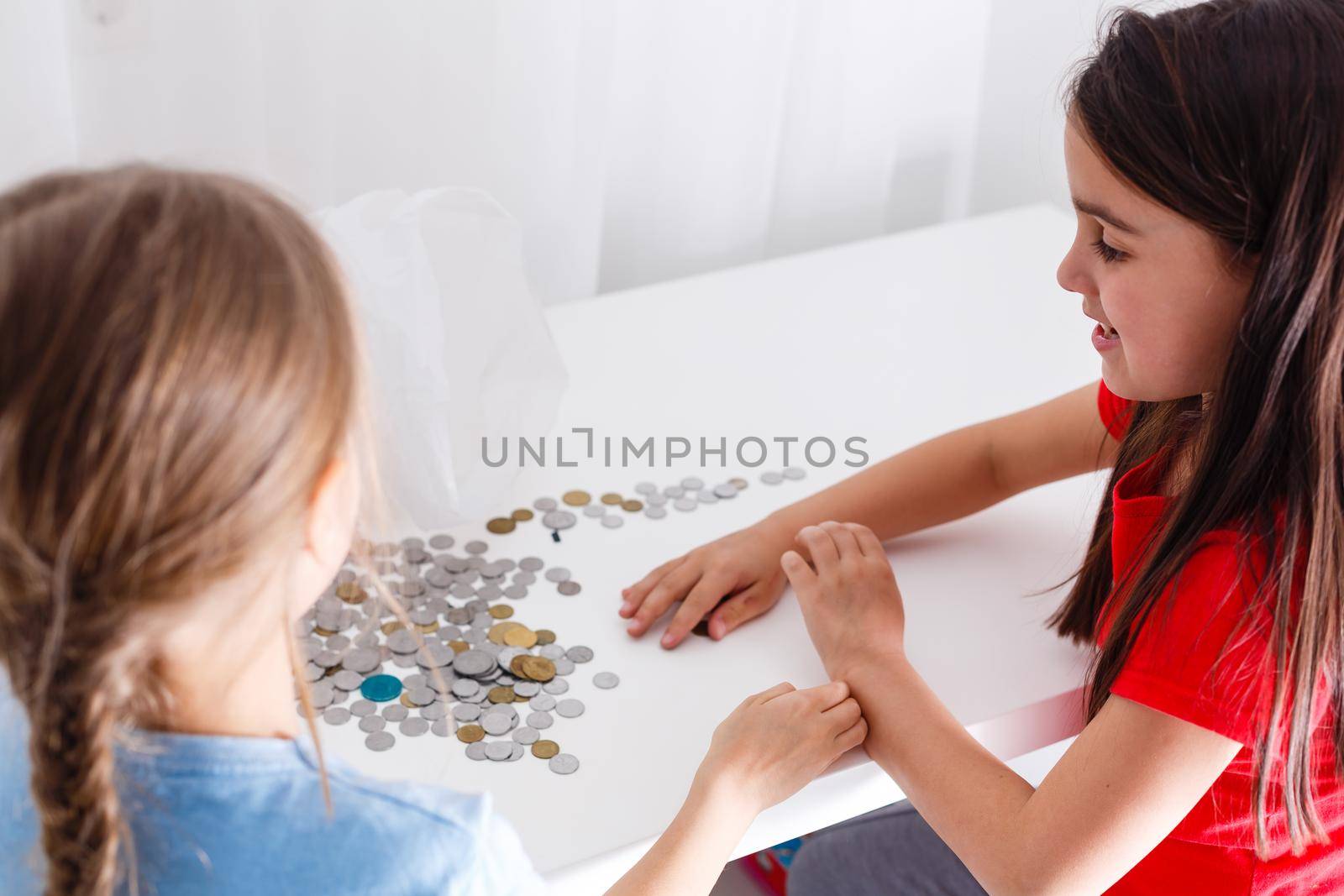 portrait of little girls sitting at table and calculating money