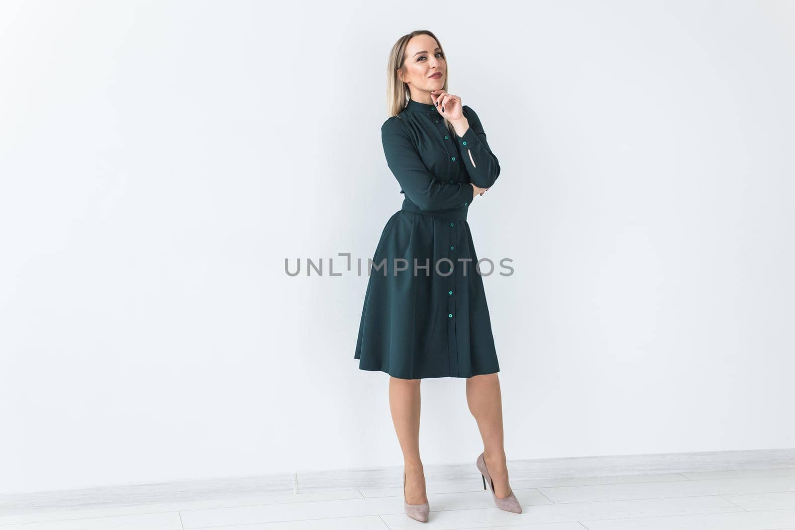 Fashionable young woman in beautiful dress posing at studio. Isolated over white.