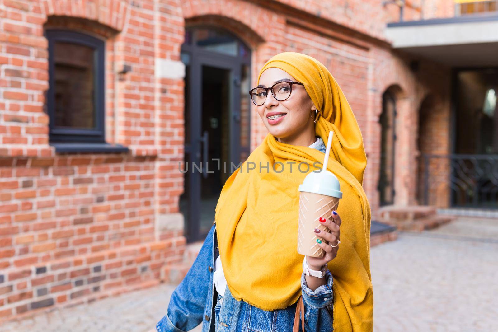 Young arabian muslim woman enjoying cocktail outdoor. by Satura86