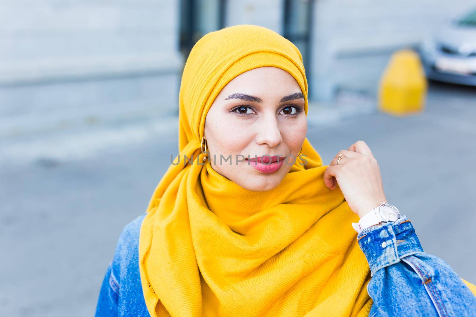 Beautiful Arabic muslim woman wearing yellow hijab, stylish female face portrait over city street. by Satura86